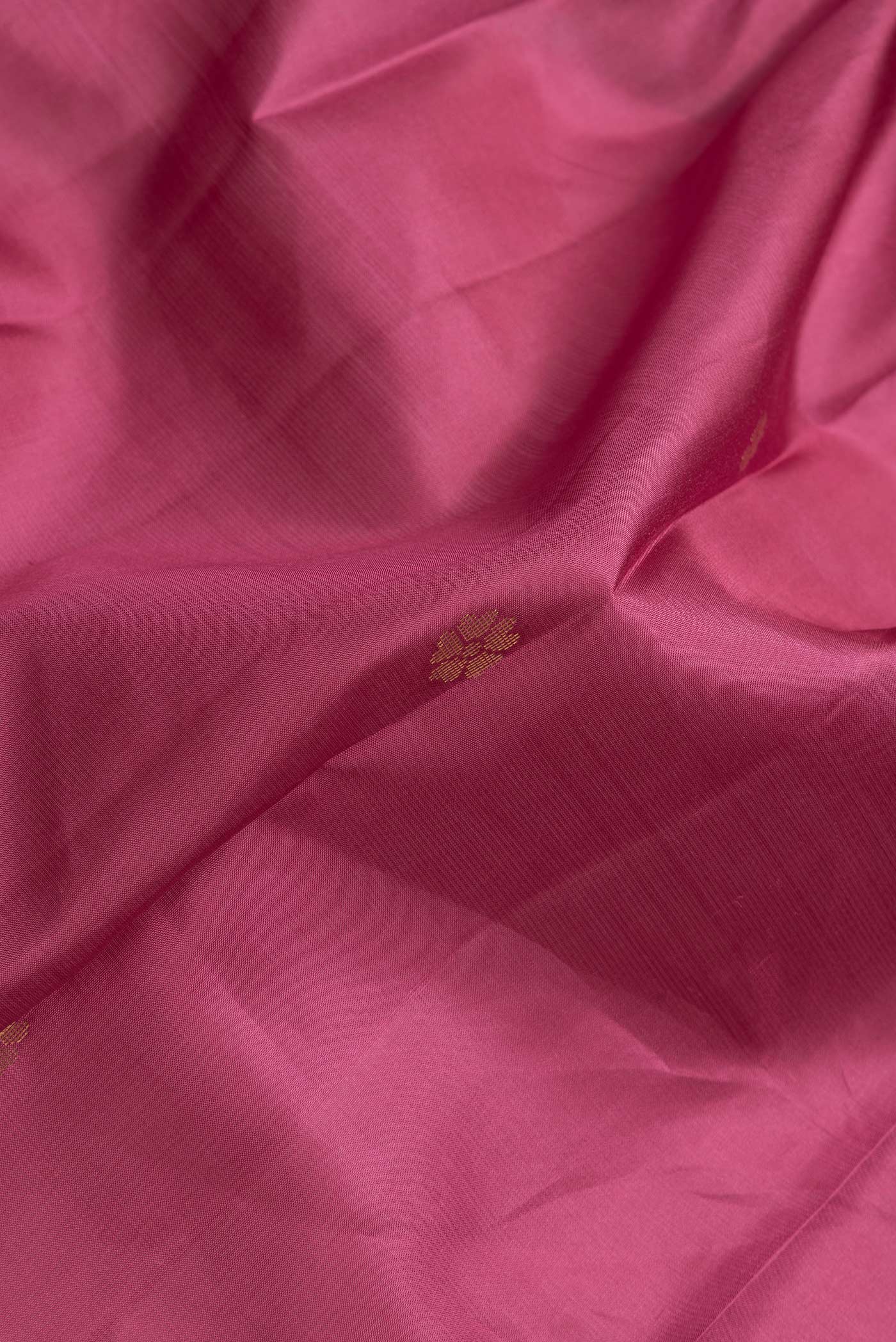 Close up of Dark Pink Dual Tone Kanjivaram Silk Saree with Zari Butta on the body and Zari Border.  displaying folds