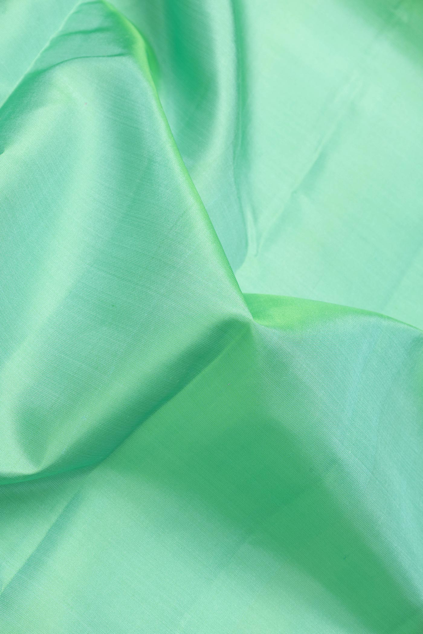 Close up of Sea Green Dual Tone Kanjivaram Silk Saree with Plain Body and Thin Zari Line.  displaying folds