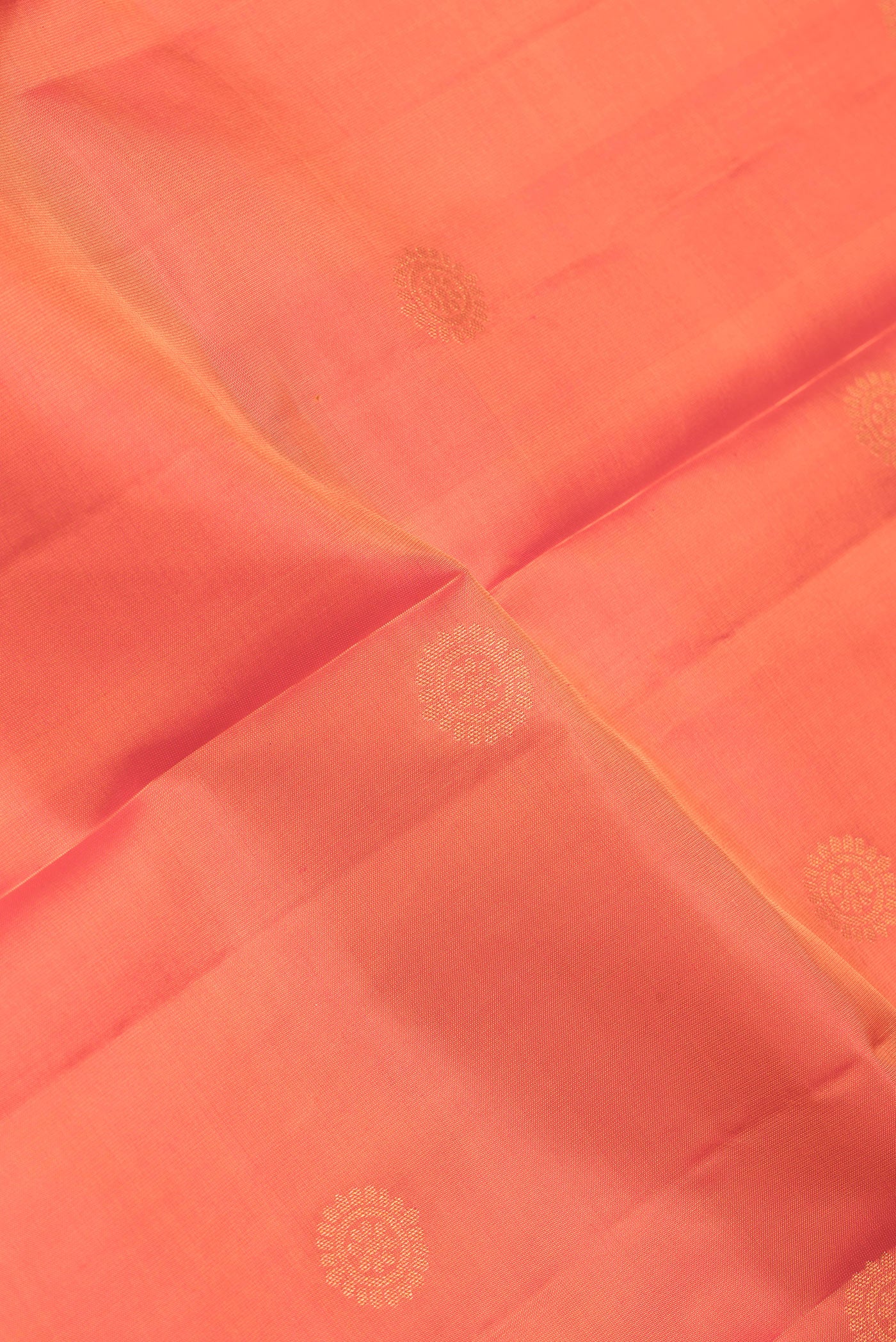 Close up of Orange Dual Tone Kanchipuram Silk Saree with Zari Butta on the body and Zari Border.  displaying folds