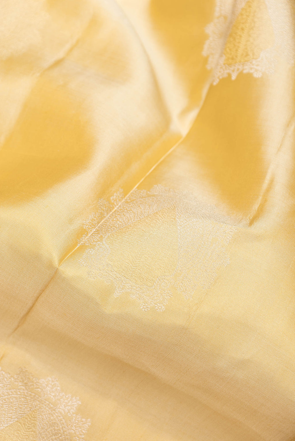 Close up of Beige Dual Tone Kanjivaram Silk Saree with Zari Butta on the body and Zari Border.  displaying folds