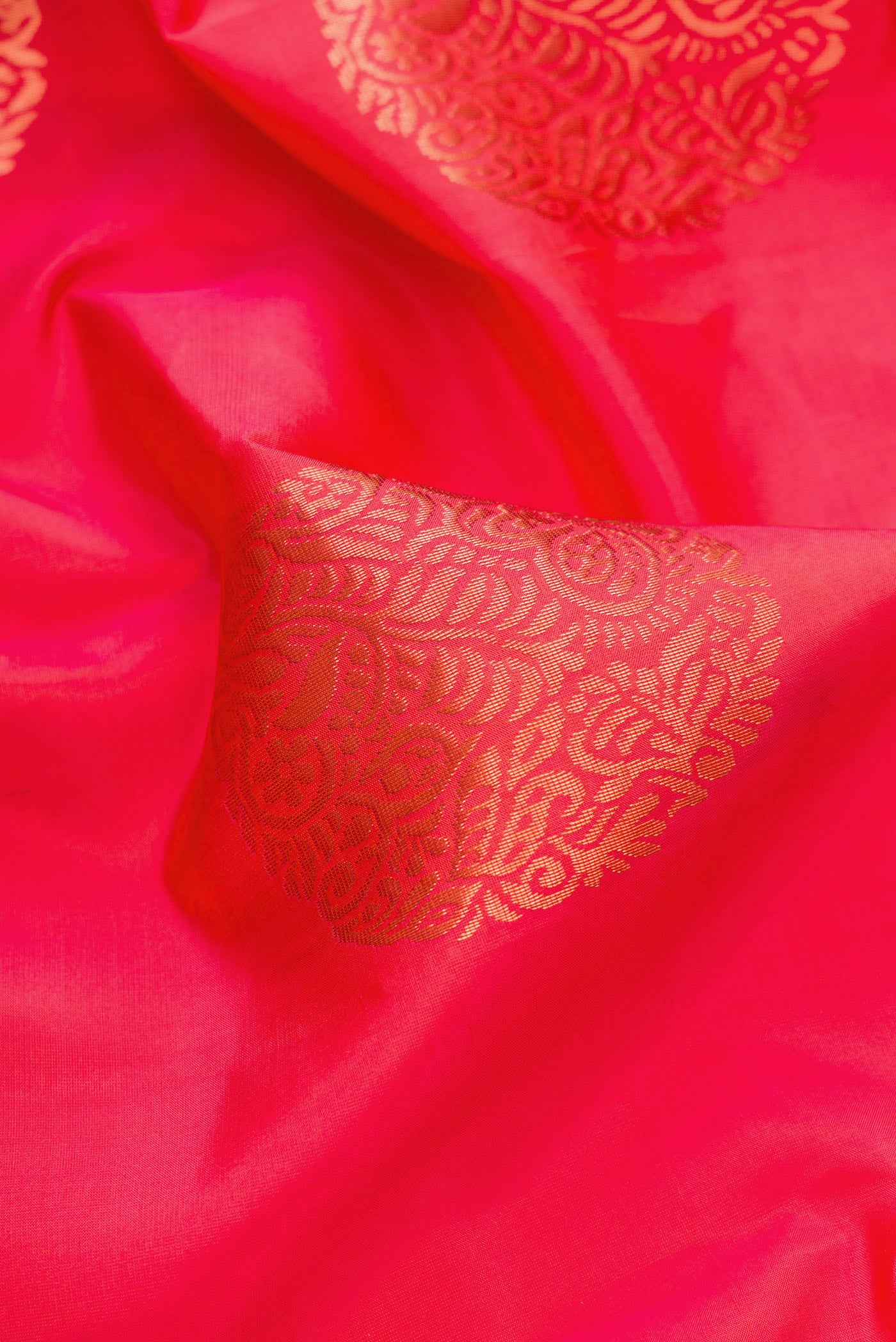 Close up of Orange Dual Tone Kanjivaram Silk Saree with Zari Butta on the body and Without Border.  displaying folds