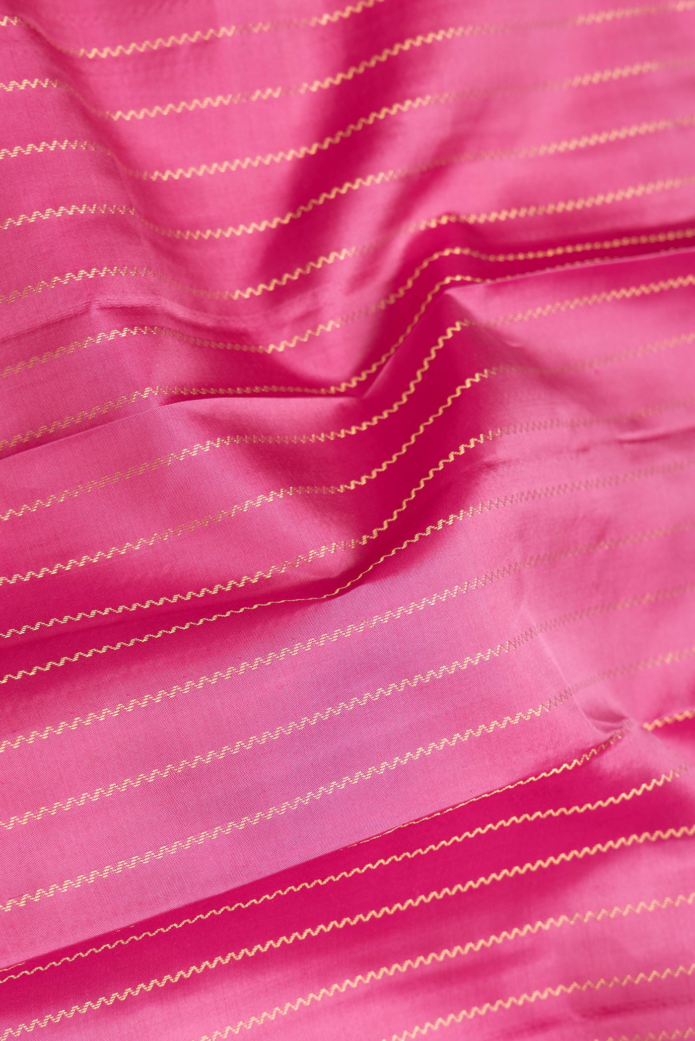 Close up of Pink Dual Tone Kanchipuram Silk Saree with Stripes on the body and Fancy Border.  displaying folds