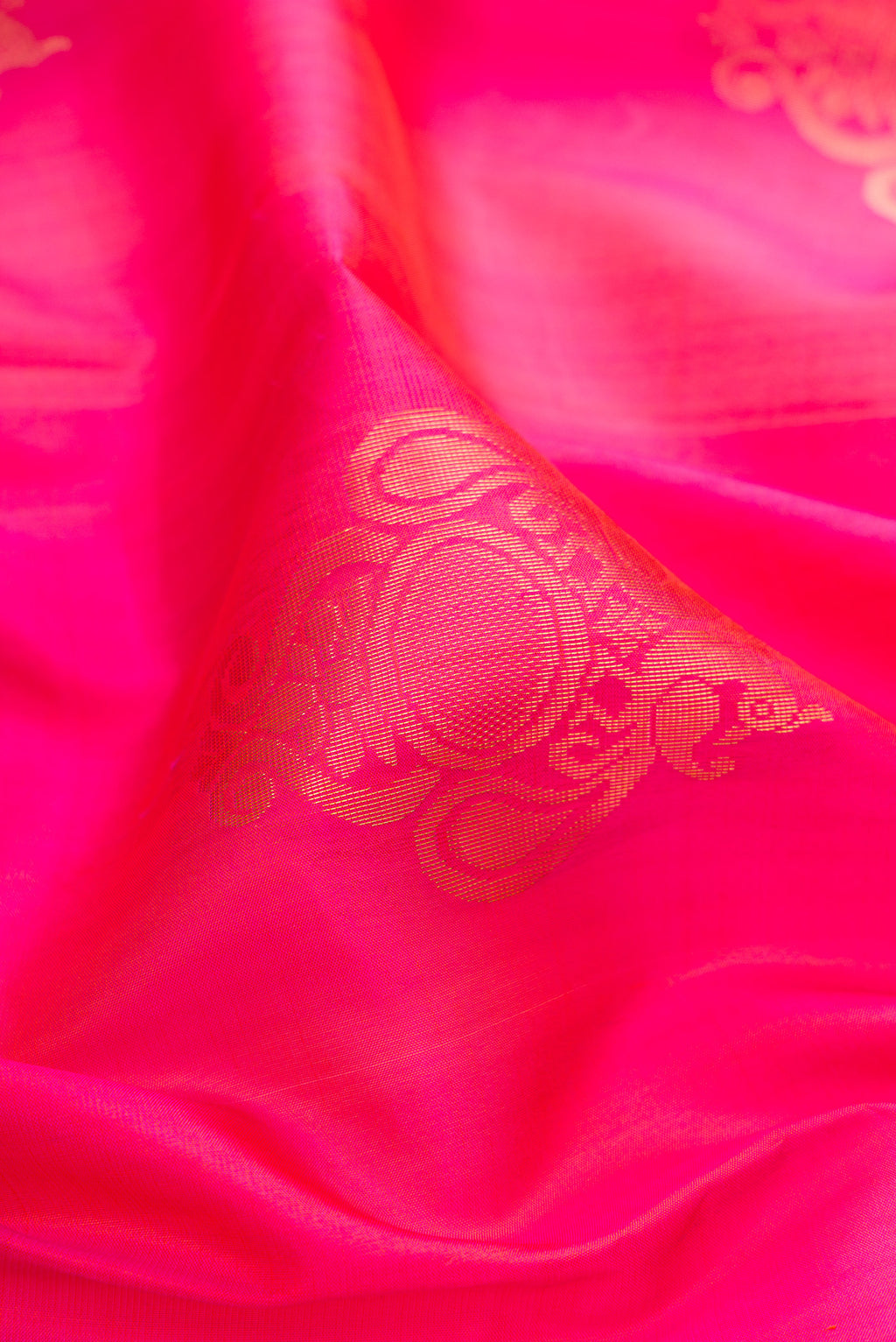 Close up of Pink Soft Silk Saree with Zari Butta on the body and Zari Border.  displaying folds
