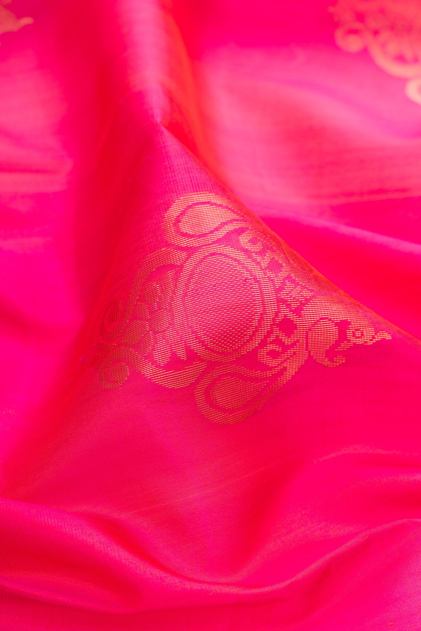 Close up of Pink Soft Silk Saree with Zari Butta on the body and Zari Border.  displaying folds