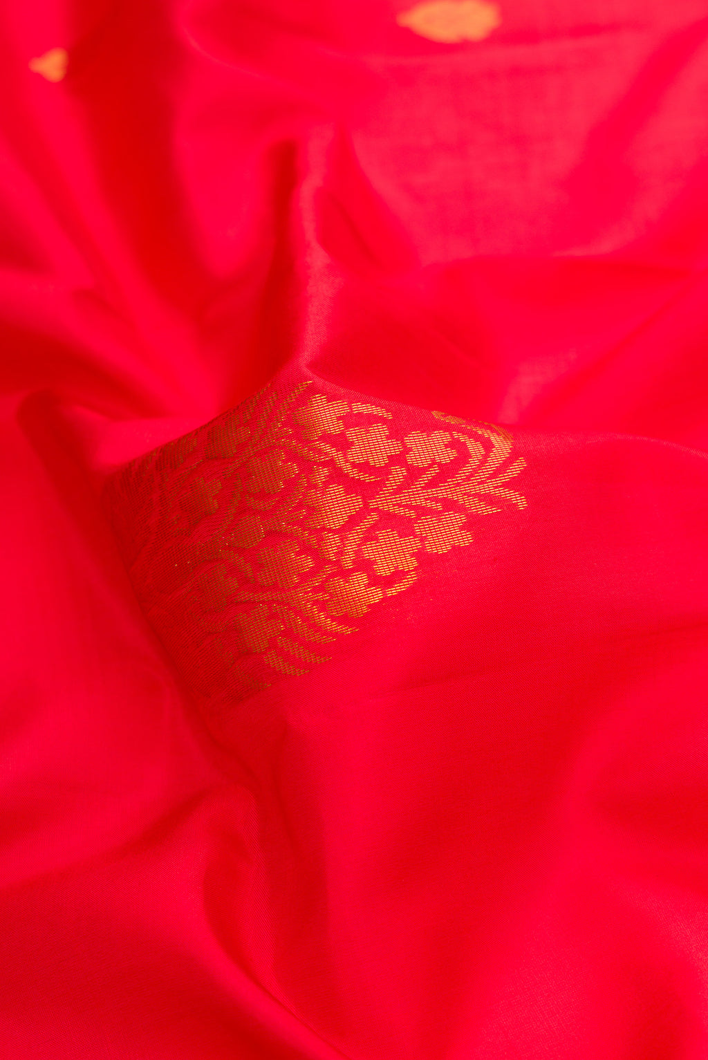 Close up of Red Dual Tone Soft Silk Saree with Zari Butta on the body and Fancy Border.  displaying folds