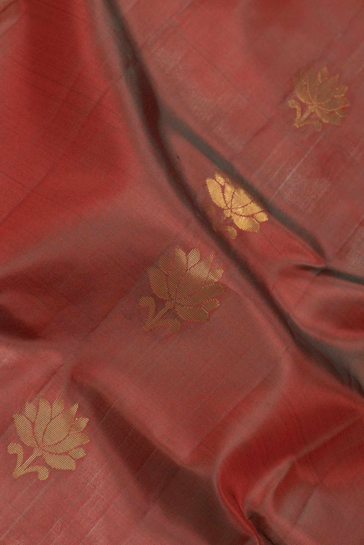 Close up of Maroon Dual Tone Soft Silk Saree with Zari Butta on the body and Zari Border.  displaying folds