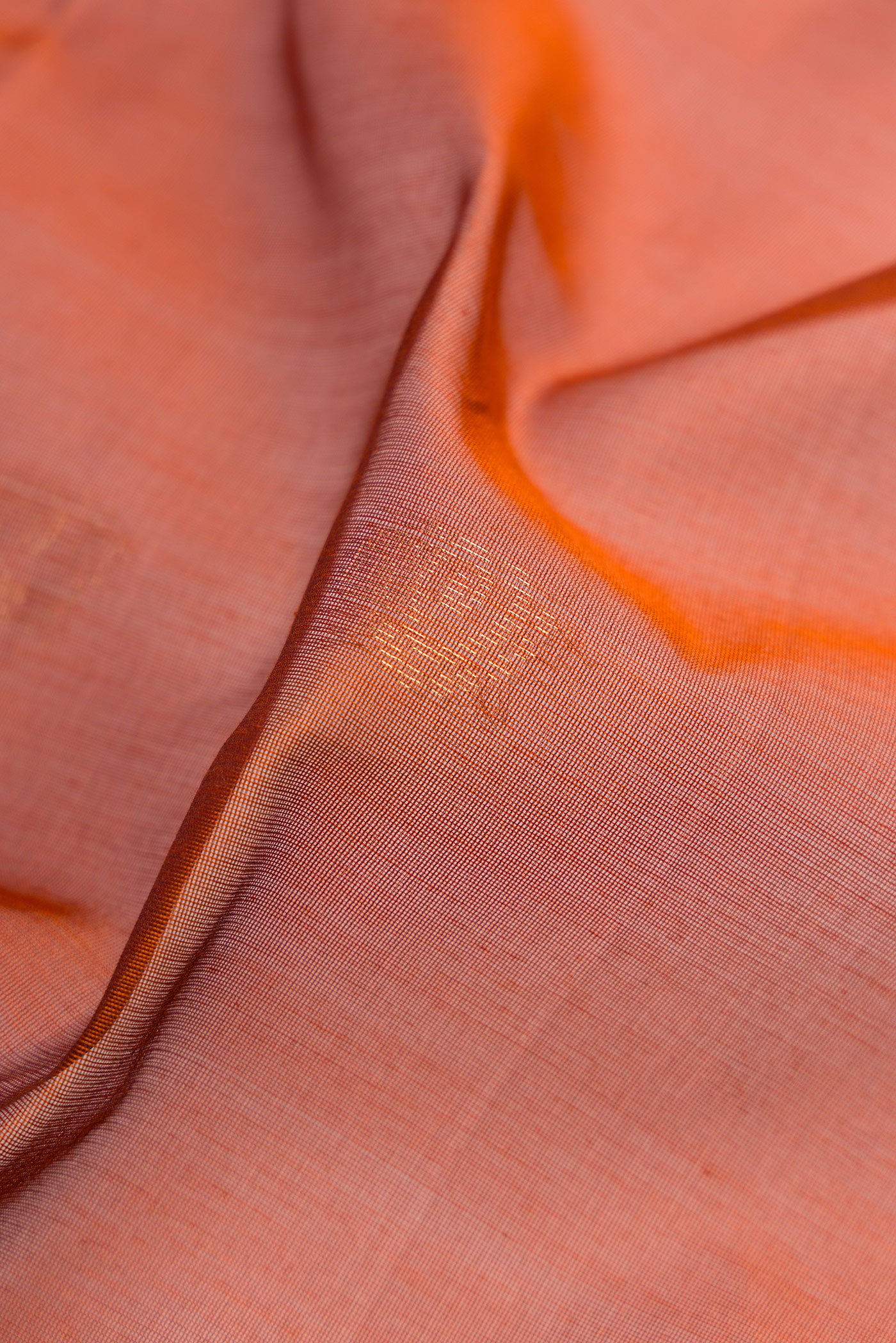 Close up of Brick Orange Dual Tone Silk Cotton Saree with Zari Butta on the body and Zari Border.  displaying folds