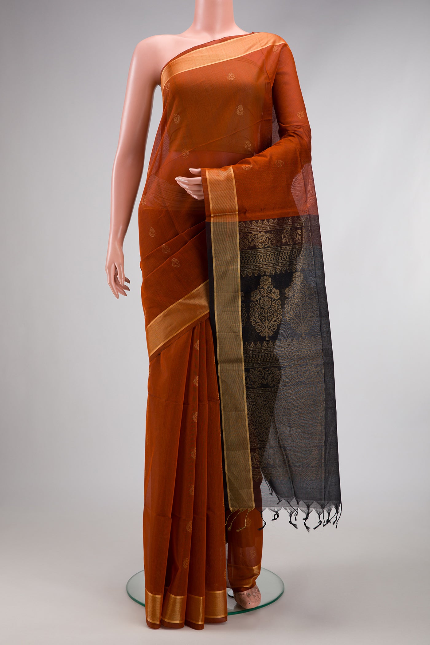 Brick Orange Dual Tone Silk Cotton Saree with Zari Butta on the body and Zari Border.  displayed on a mannequin