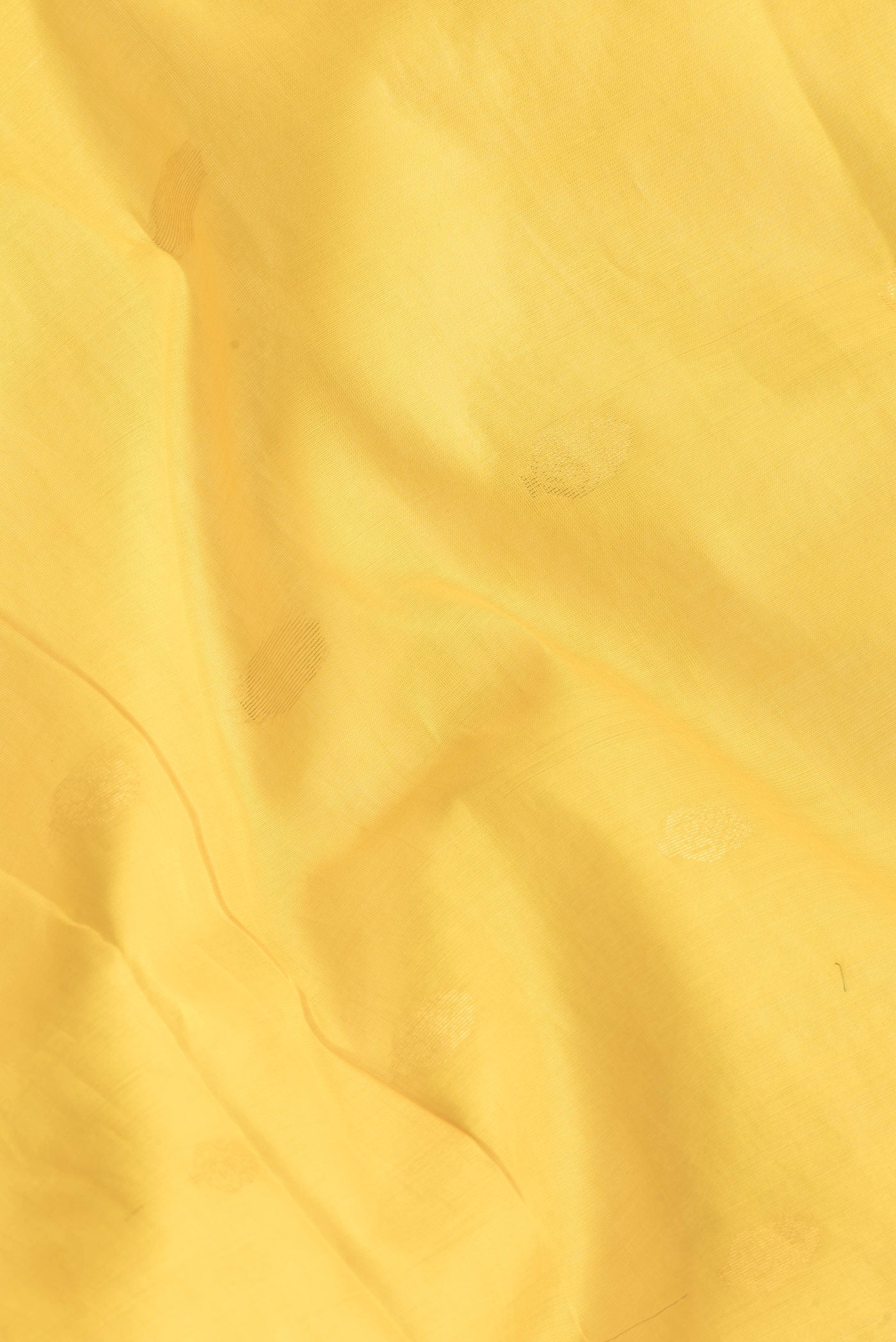 Close up of Yellow Dual Tone Silk Cotton Saree with Zari Butta on the body and Zari Border.  displaying folds