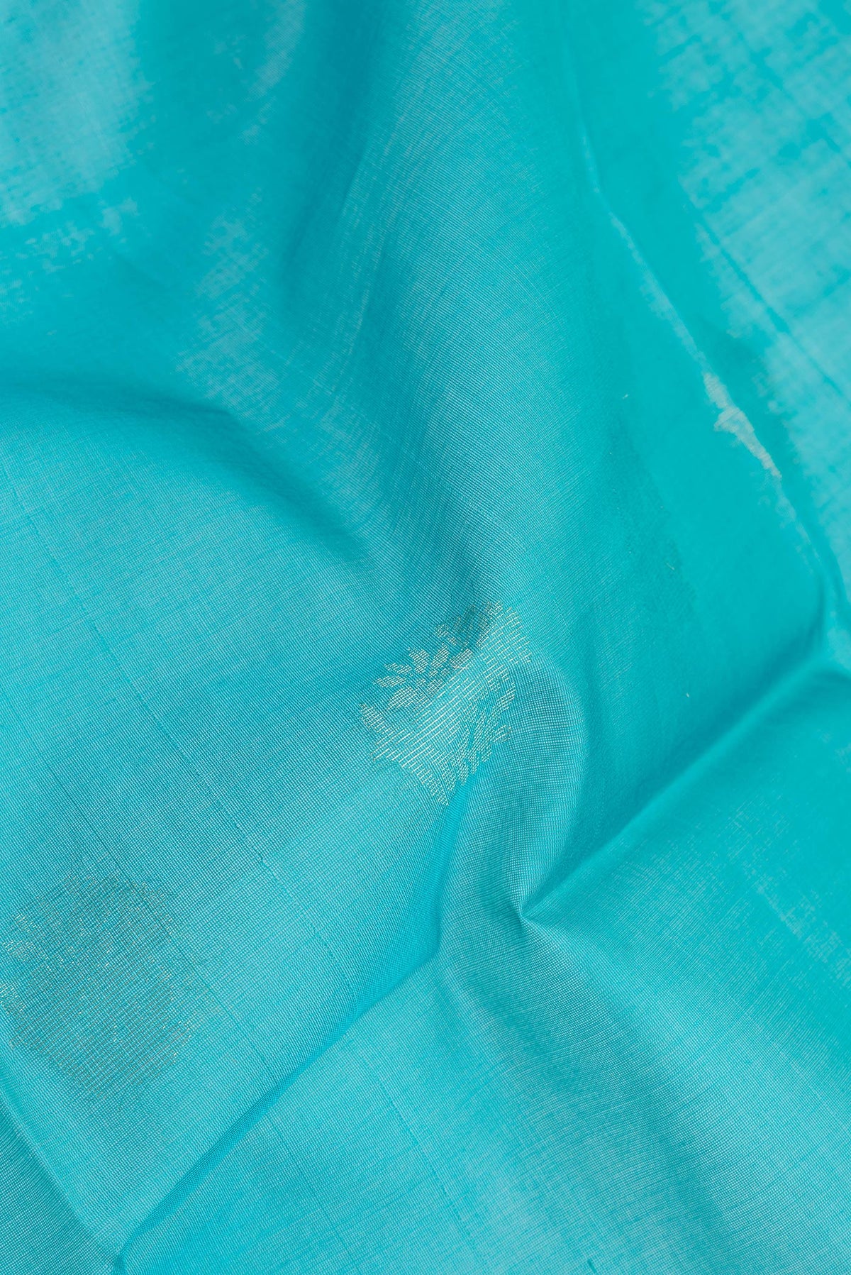Close up of Sky Blue Silk Cotton Saree with Zari Butta on the body and Zari Border.  displaying folds