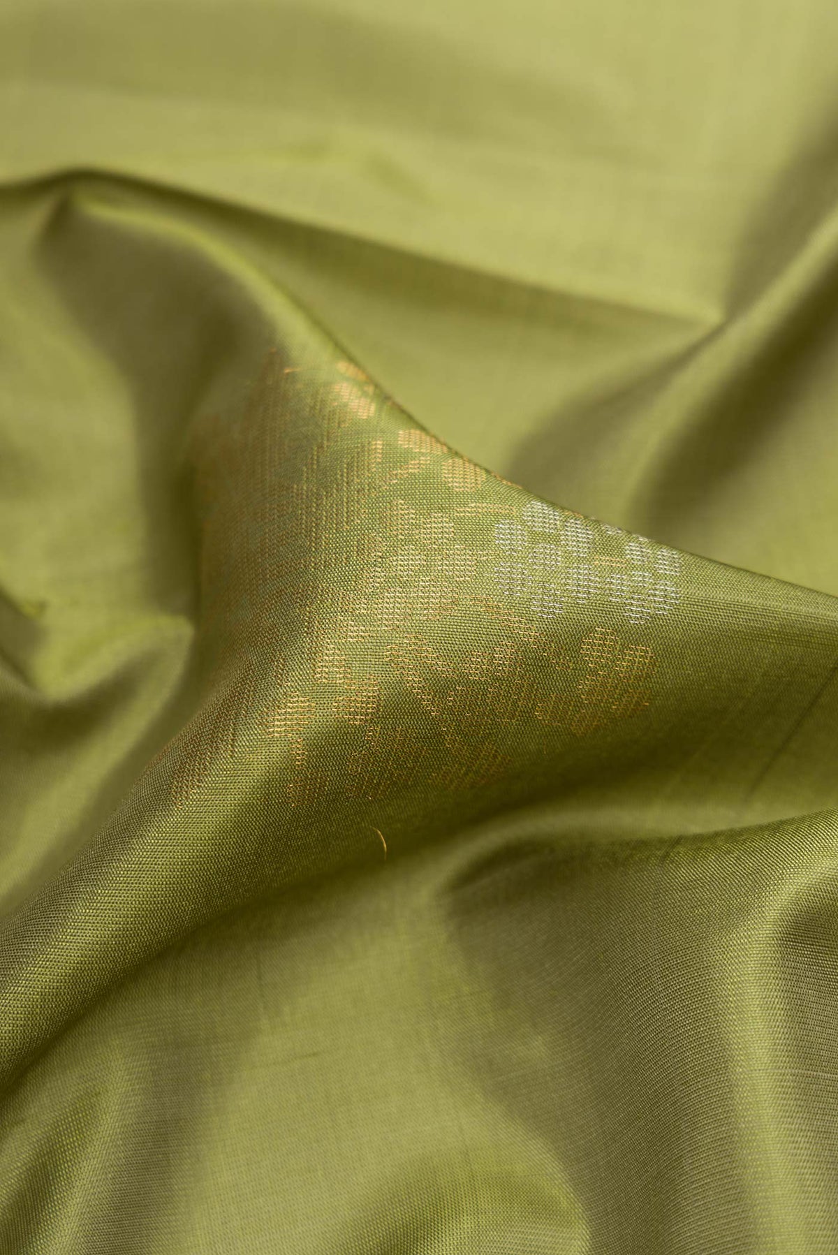 Close up of Mehandi Green Dual Tone Soft Silk Saree with Zari Butta on the body and Zari Border displaying folds