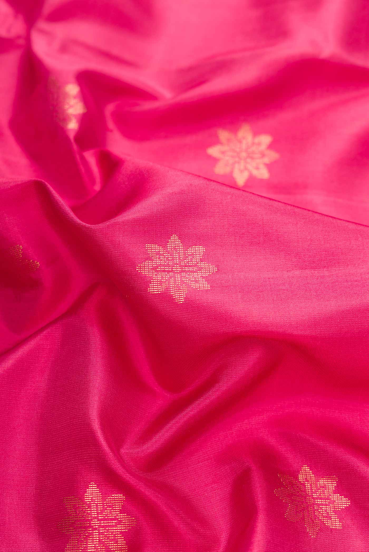 Close up of Pink Dual Tone Soft Silk Saree with Zari Butta on the body and Zari Border.  displaying folds