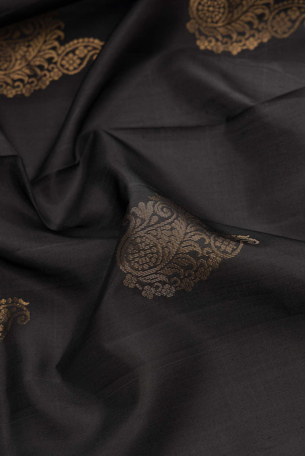 Close up of Black Dual Tone Soft Silk Saree with Zari Butta on the body and Zari Border.  displaying folds