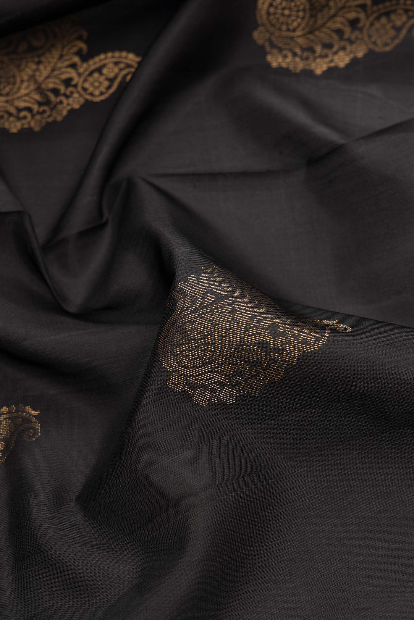 Close up of Black Dual Tone Soft Silk Saree with Zari Butta on the body and Zari Border.  displaying folds