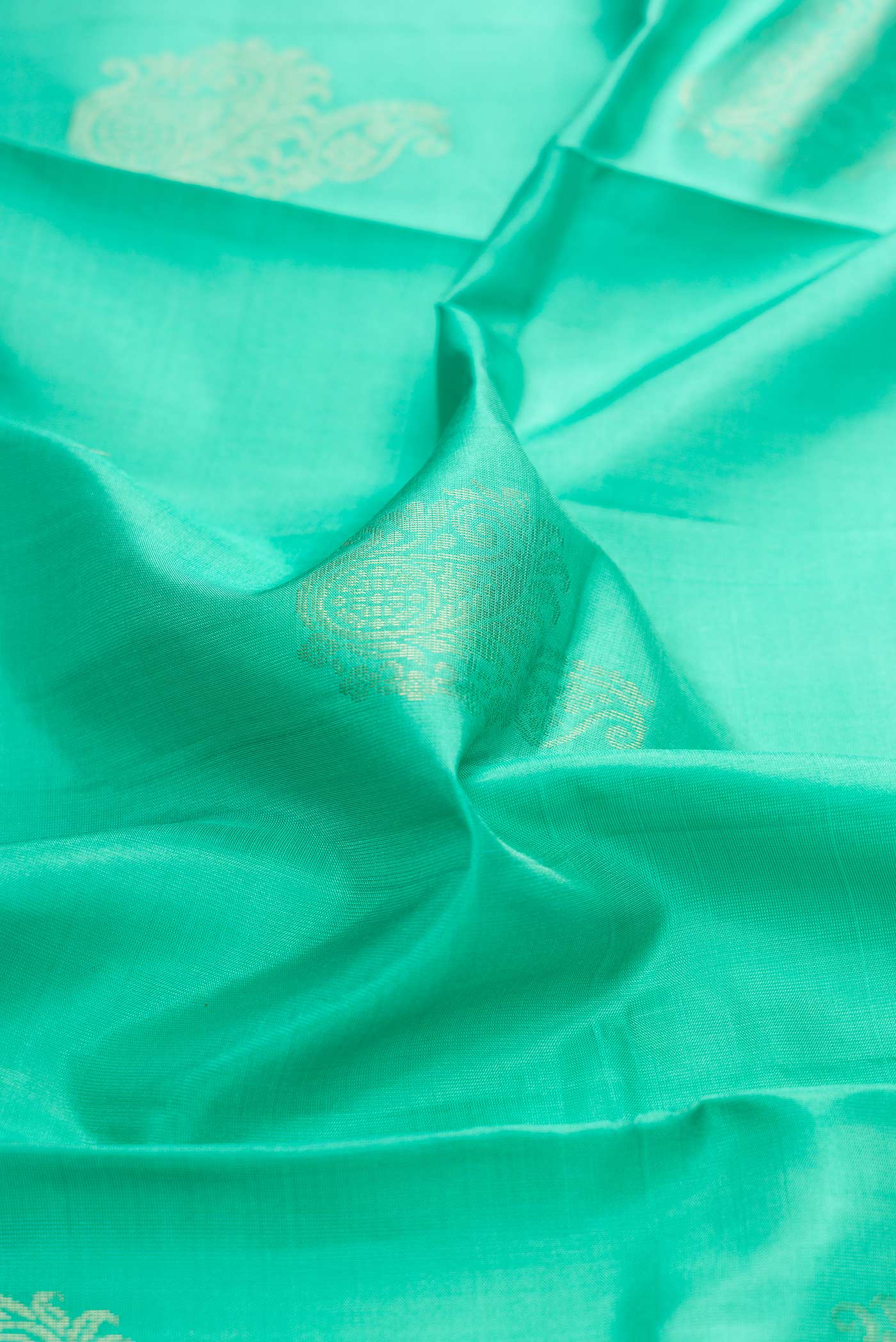 Close up of Sea Green Dual Tone Soft Silk Saree with Zari Butta on the body and Zari Border displaying folds