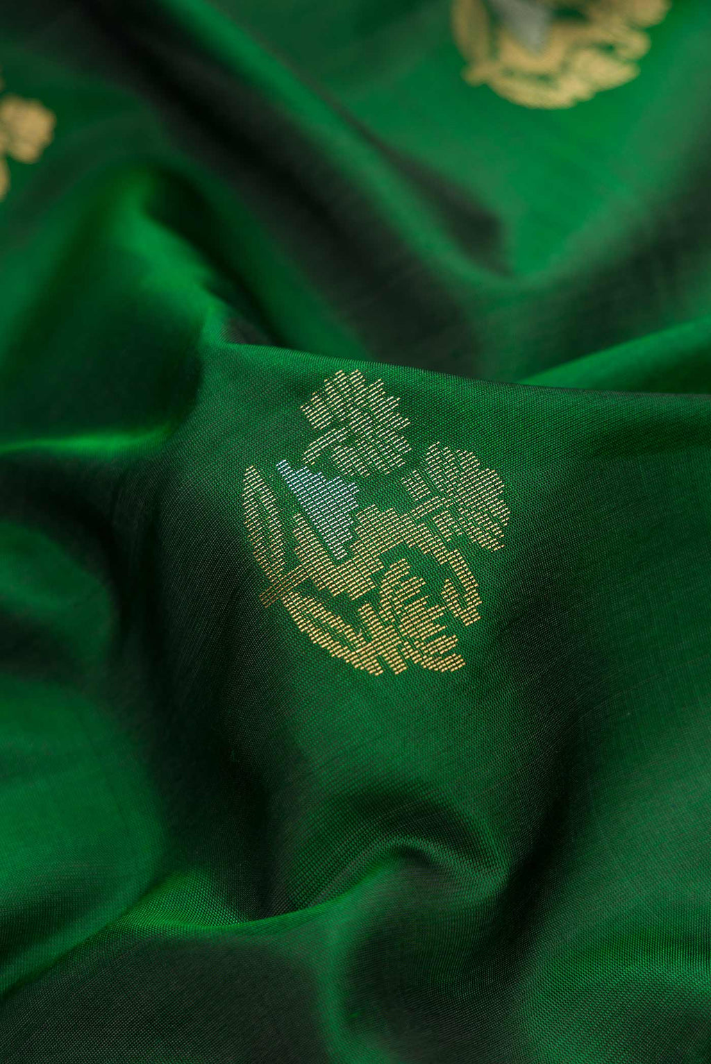 Close up of Bottle Green Dual Tone Soft Silk Saree with Zari Butta on the body and Zari Border.  displaying folds