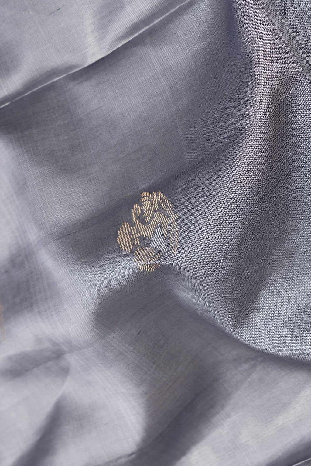 Close up of Grey Dual Tone Soft Silk Saree with Zari Butta on the body and Zari Border.  displaying folds