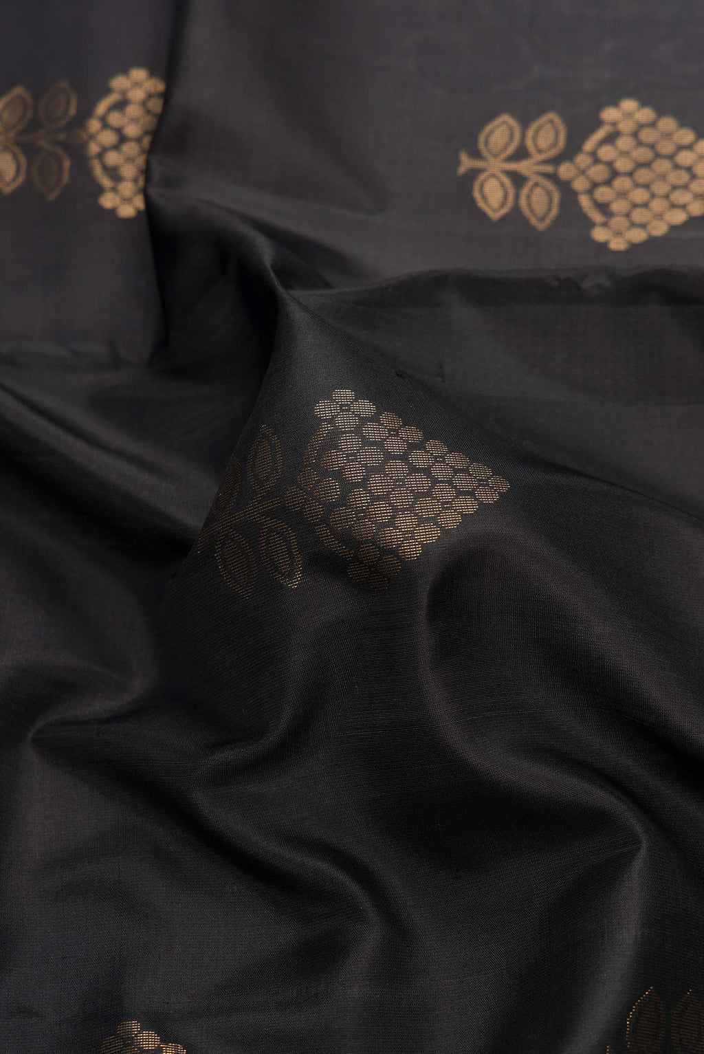 Close up of Black Dual Tone Soft Silk Saree with Zari Butta on the body and Zari Border.  displaying folds