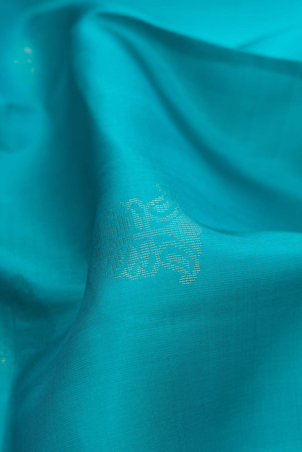 Close up of Sky Blue Dual Tone Soft Silk Saree with Zari Butta on the body and Zari Border.  displaying folds