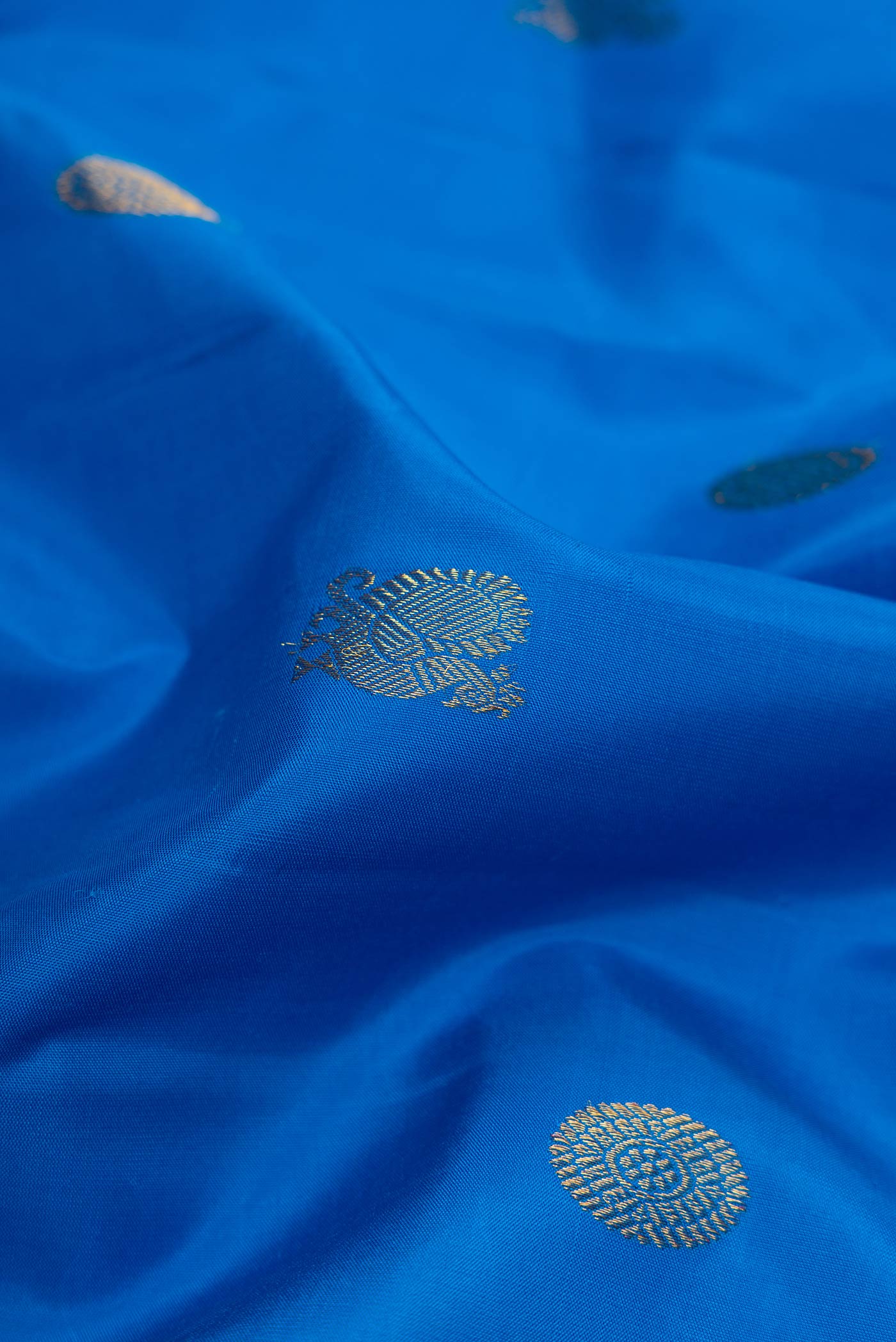 Close up of Royal Blue Kanchipuram Silk Saree with Zari Butta on the body and Zari Border displaying folds