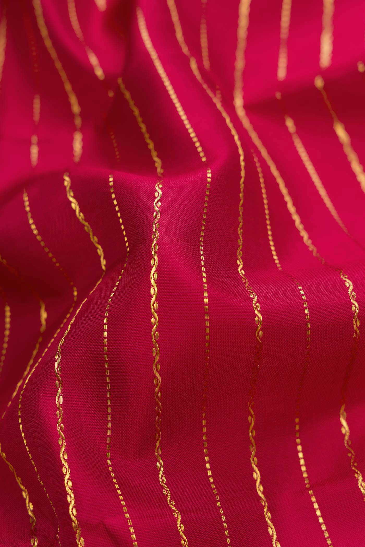 Close up of Maroon Dual Tone Kanchipuram Silk Saree with Checked design on the body and Zari Border.  displaying folds