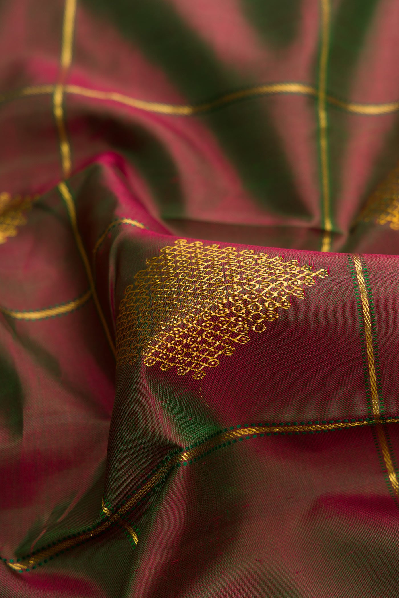 Close up of Mehandi Green Dual Tone Kanchipuram Silk Saree with Checked design on the body and Thin Zari Line.  displaying folds