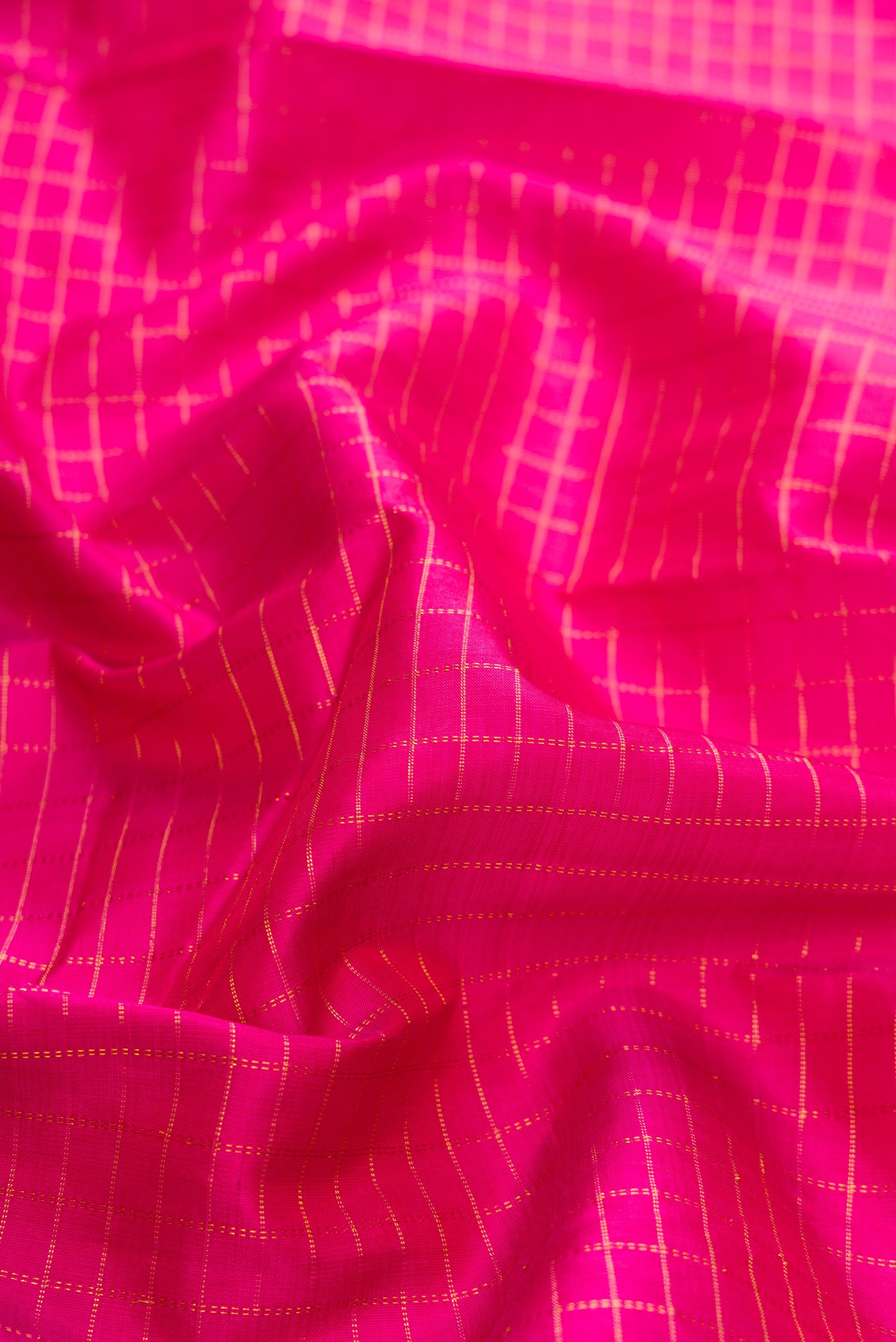 Close up of Pink Dual Tone Kanchipuram Silk Saree with Checked design on the body and Zari Border.  displaying folds