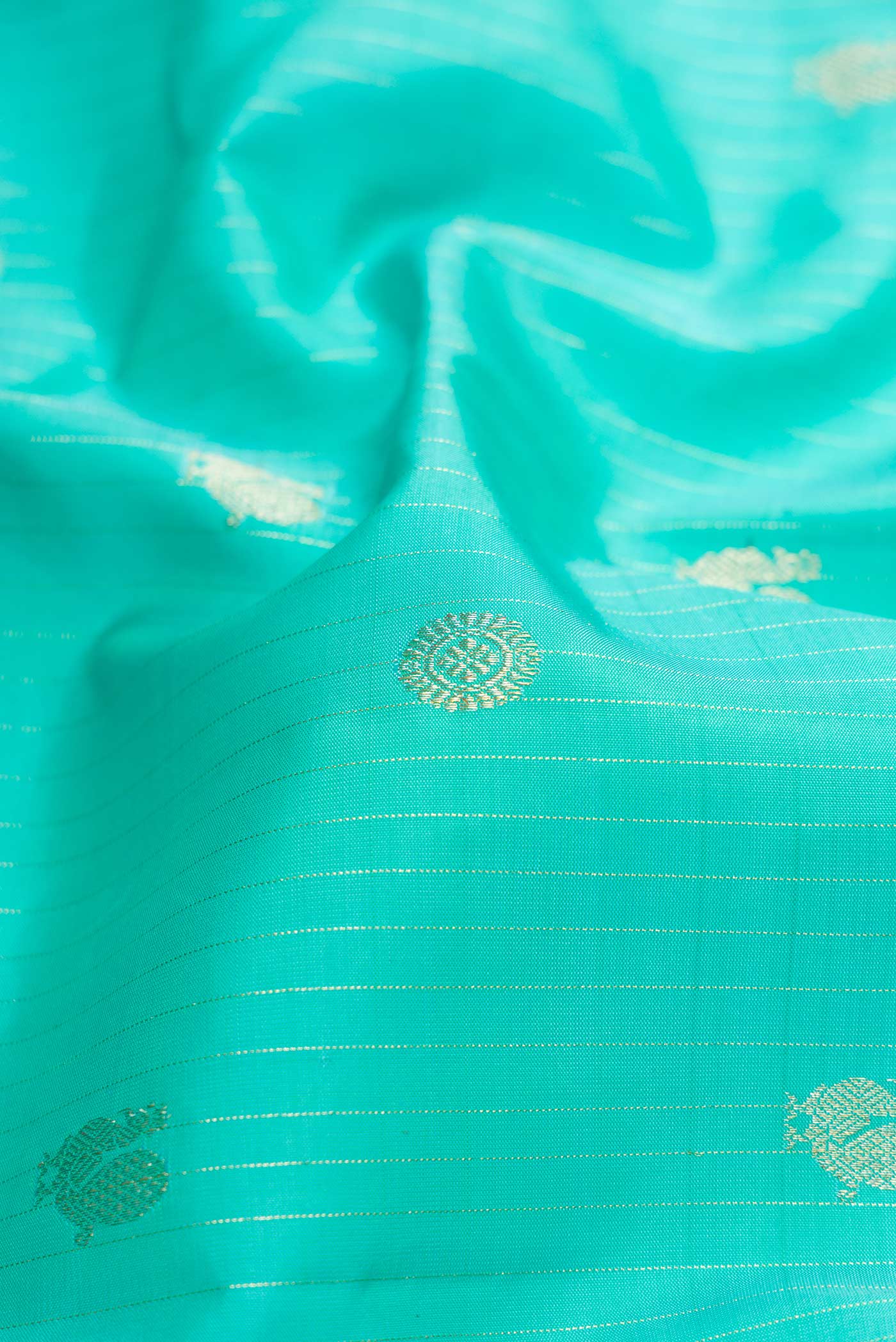 Close up of Sea Green Dual Tone Kanchipuram Silk Saree with Stripes on the body and Zari Border.  displaying folds