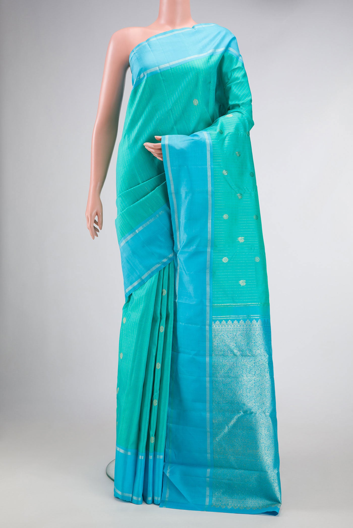 Sea Green Dual Tone Kanchipuram Silk Saree with Stripes on the body and Zari Border.  displayed on a mannequin
