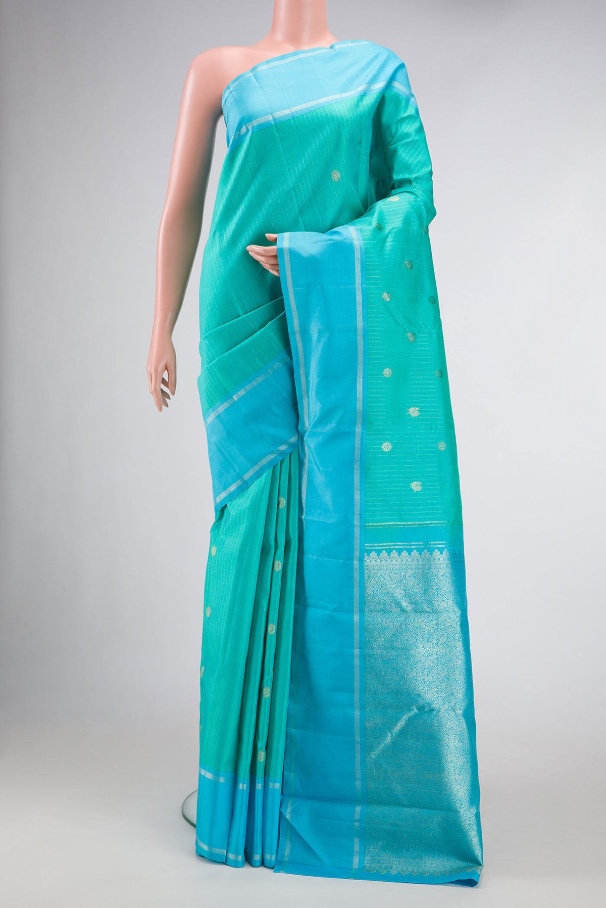 Sea Green Dual Tone Kanchipuram Silk Saree with Stripes on the body and Zari Border.  displayed on a mannequin