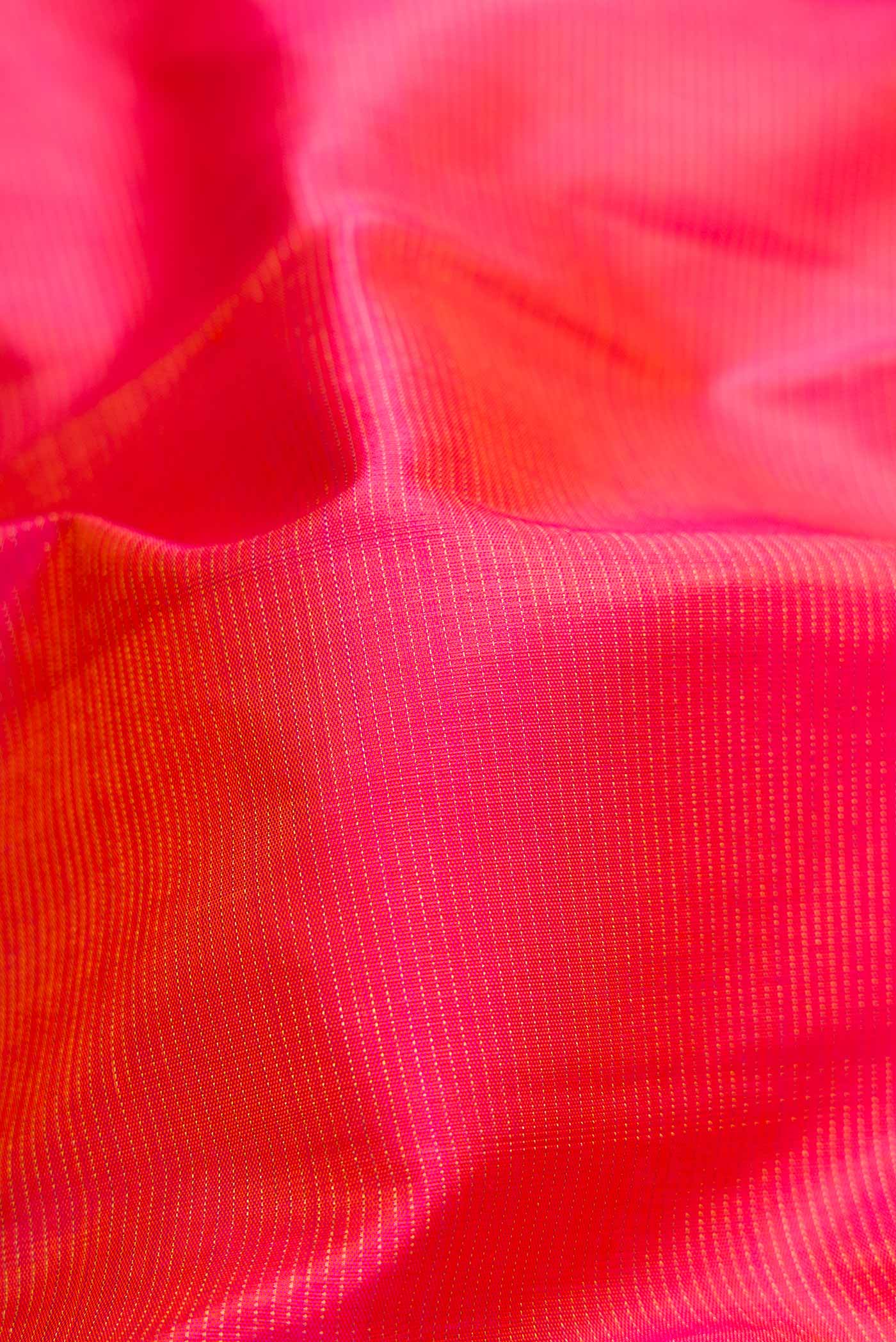 Close up of Brick Orange Dual Tone Kanchipuram Silk Saree with Stripes on the body and Zari Border.  displaying folds