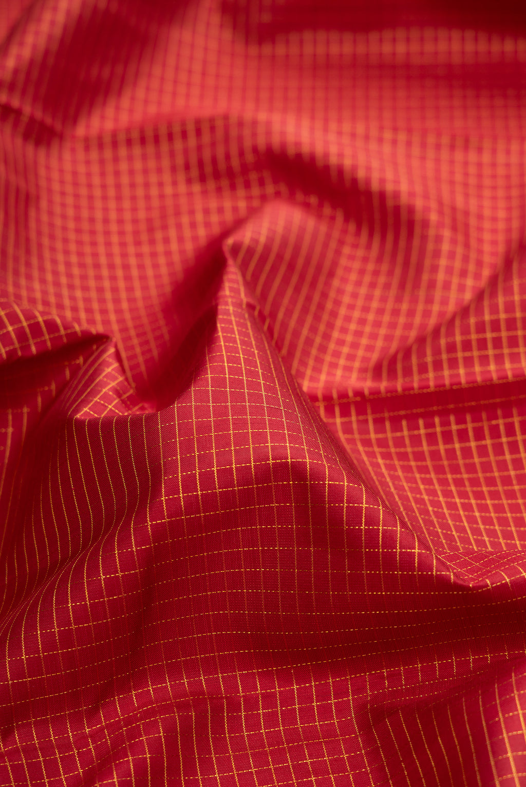 Close up of Pure Silk Maroon Kanchipuram Saree with Checked design on the body and Zari Border.  displaying folds