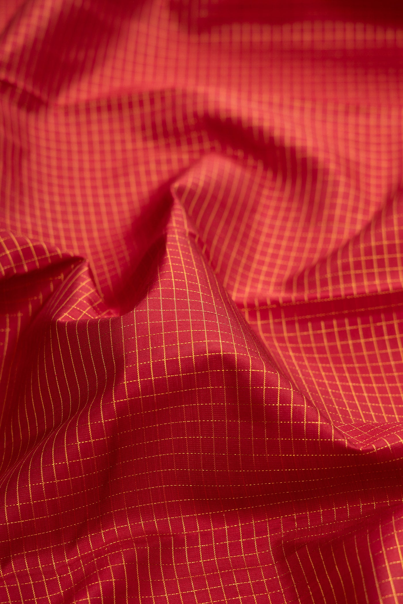 Close up of Pure Silk Maroon Kanchipuram Saree with Checked design on the body and Zari Border.  displaying folds