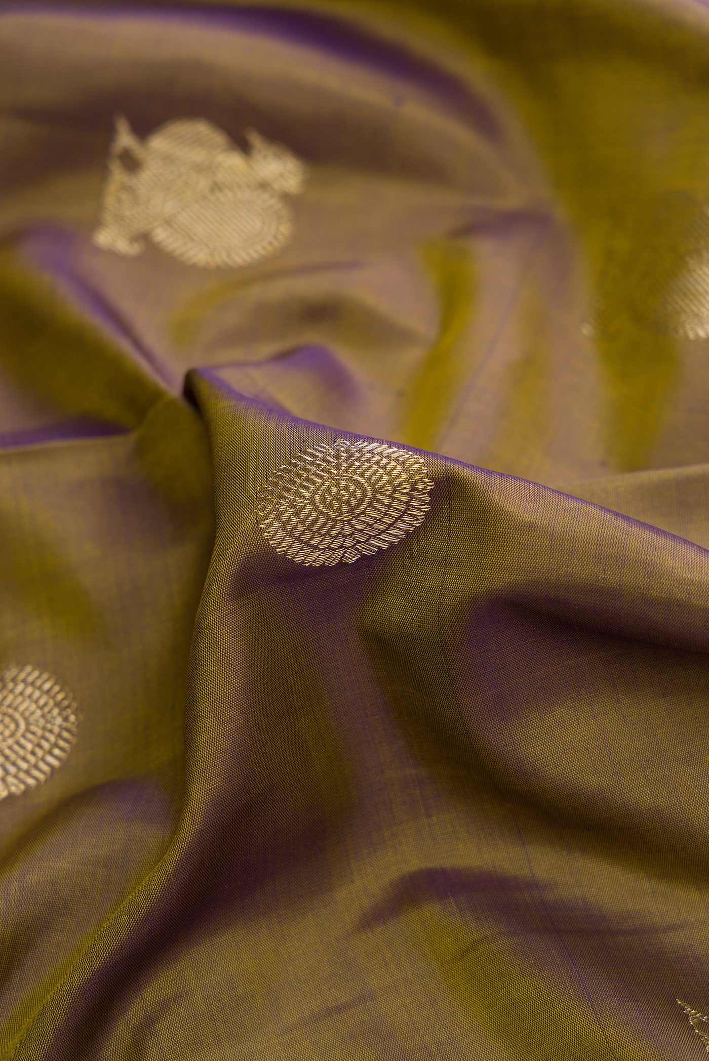 Close up of Mehandi Green Dual Tone Kanchipuram Silk Saree with Zari Butta on the body and Checks Border.  displaying folds