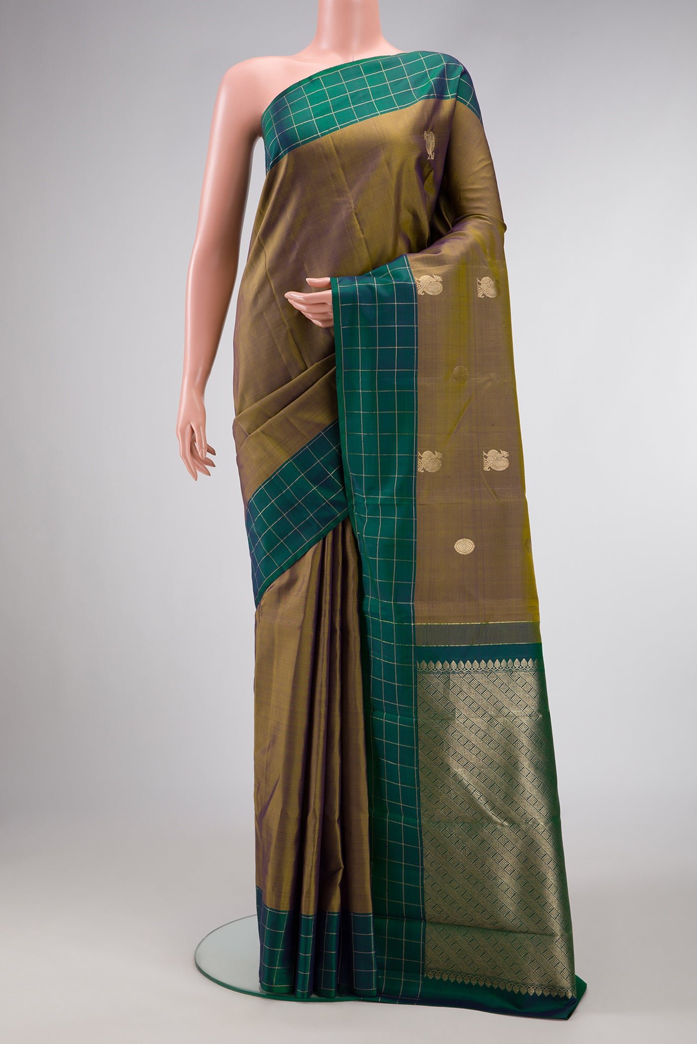 Mehandi Green Dual Tone Kanchipuram Silk Saree with Zari Butta on the body and Checks Border.  displayed on a mannequin