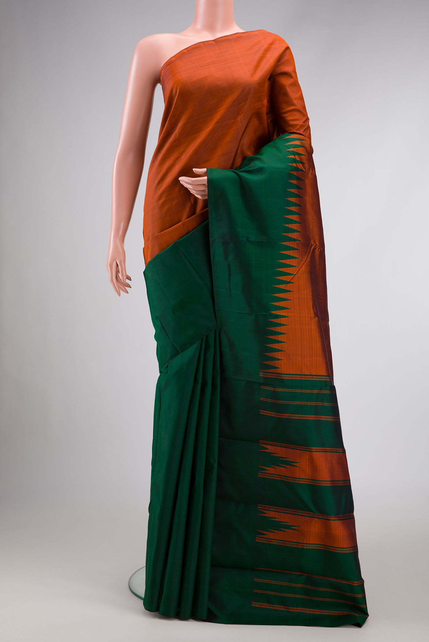 Brick Orange Dual Tone Kanchipuram Silk Saree with Plain Body and Rising Temple Border.  displayed on a mannequin