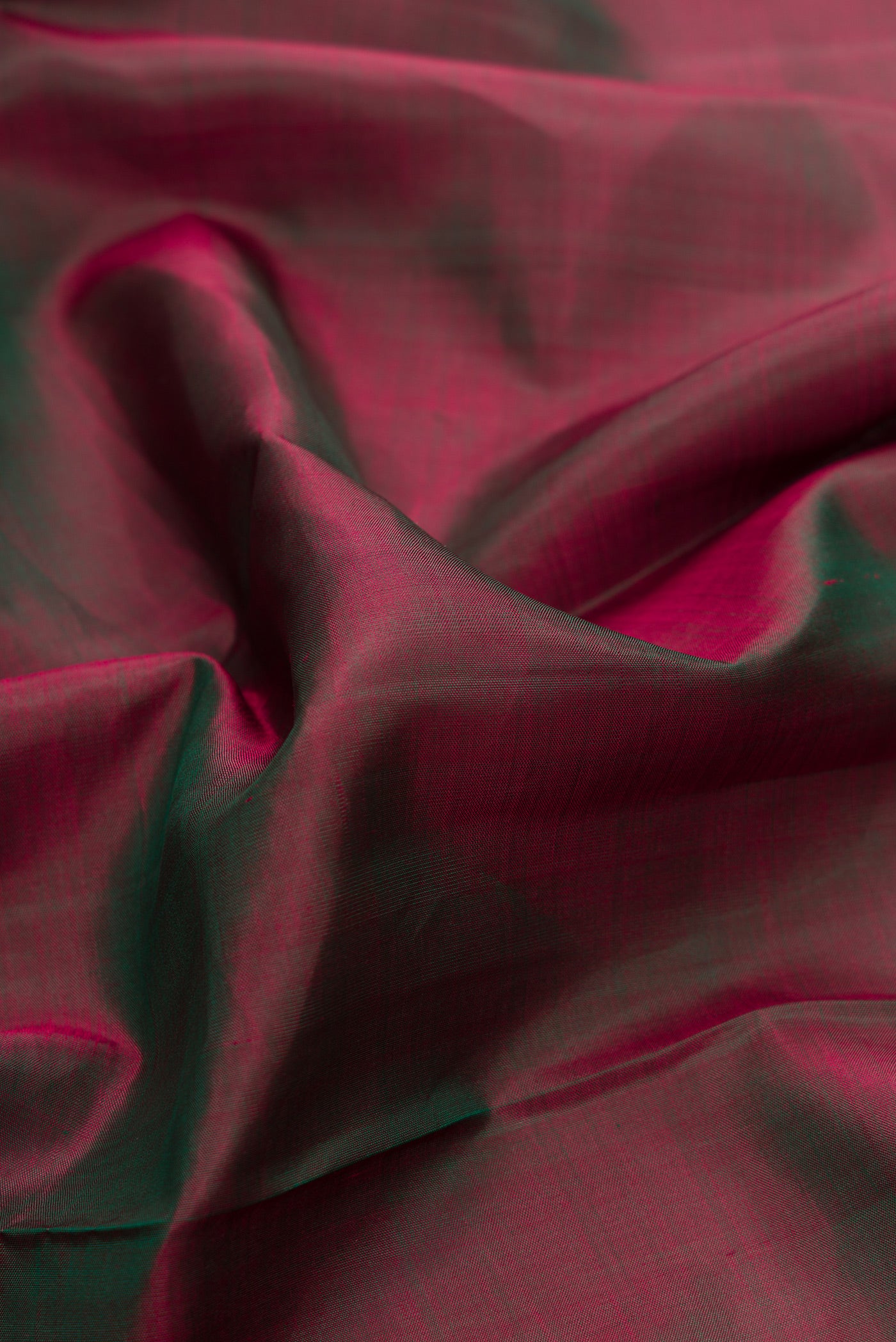 Close up of Green Dual Tone Kanchipuram Silk Saree with Plain Body and Zari Border.  displaying folds