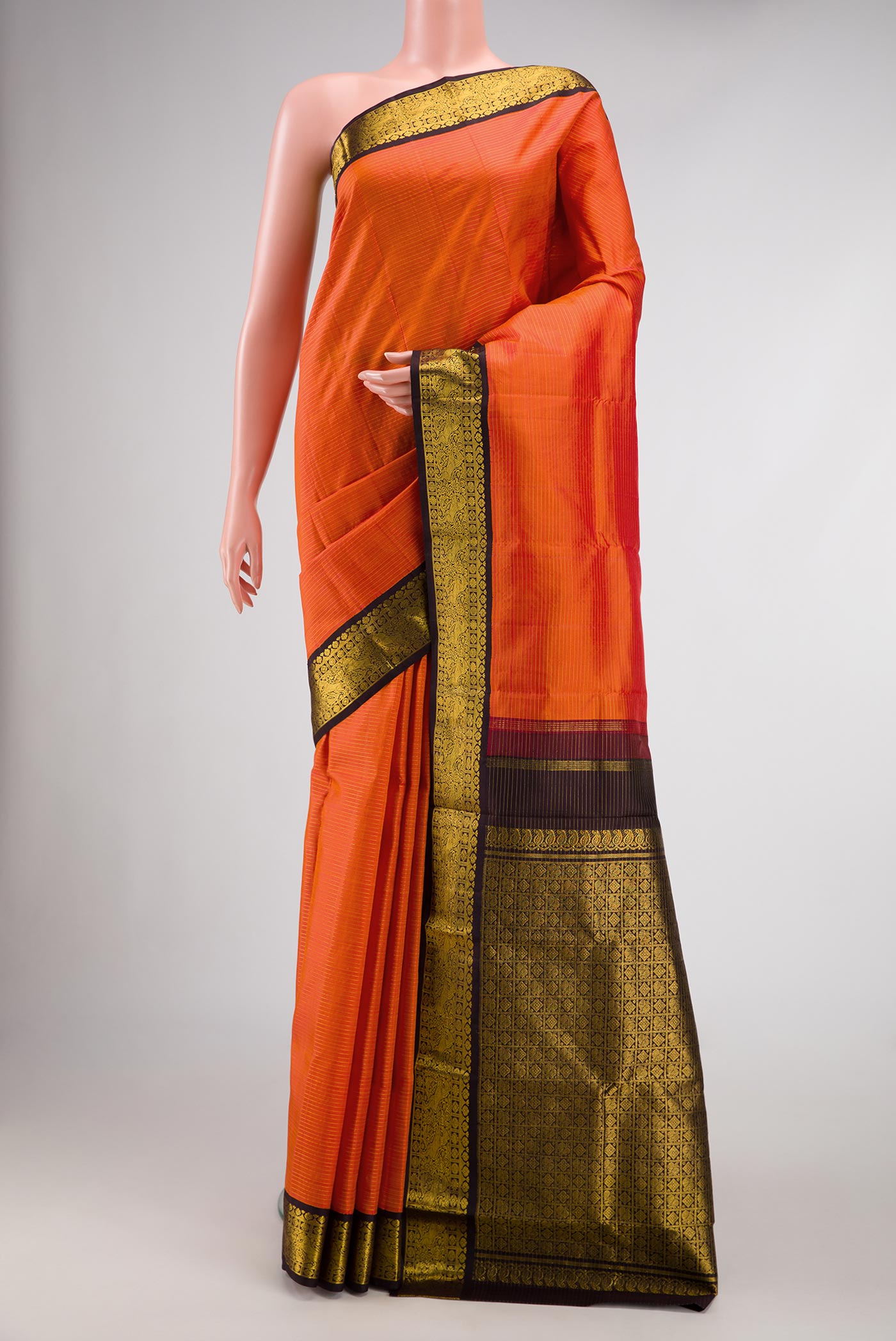 Orange Dual Tone Kanjivaram Silk Saree with Zari And Thread Butta on the body and Zari Border.  displayed on a mannequin