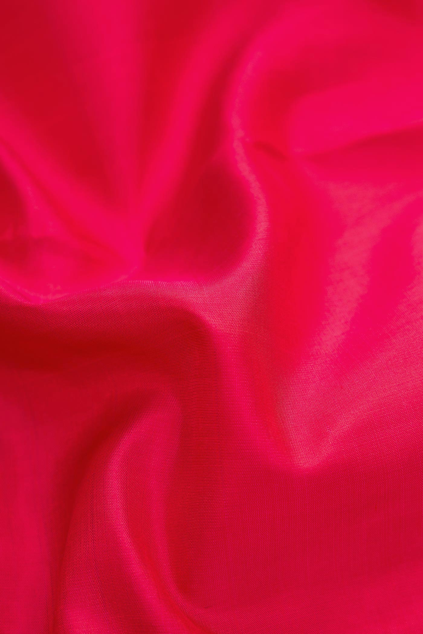 Close up of Red Dual Tone Kanjivaram Silk Saree with Plain Body and Zari Border.  displaying folds