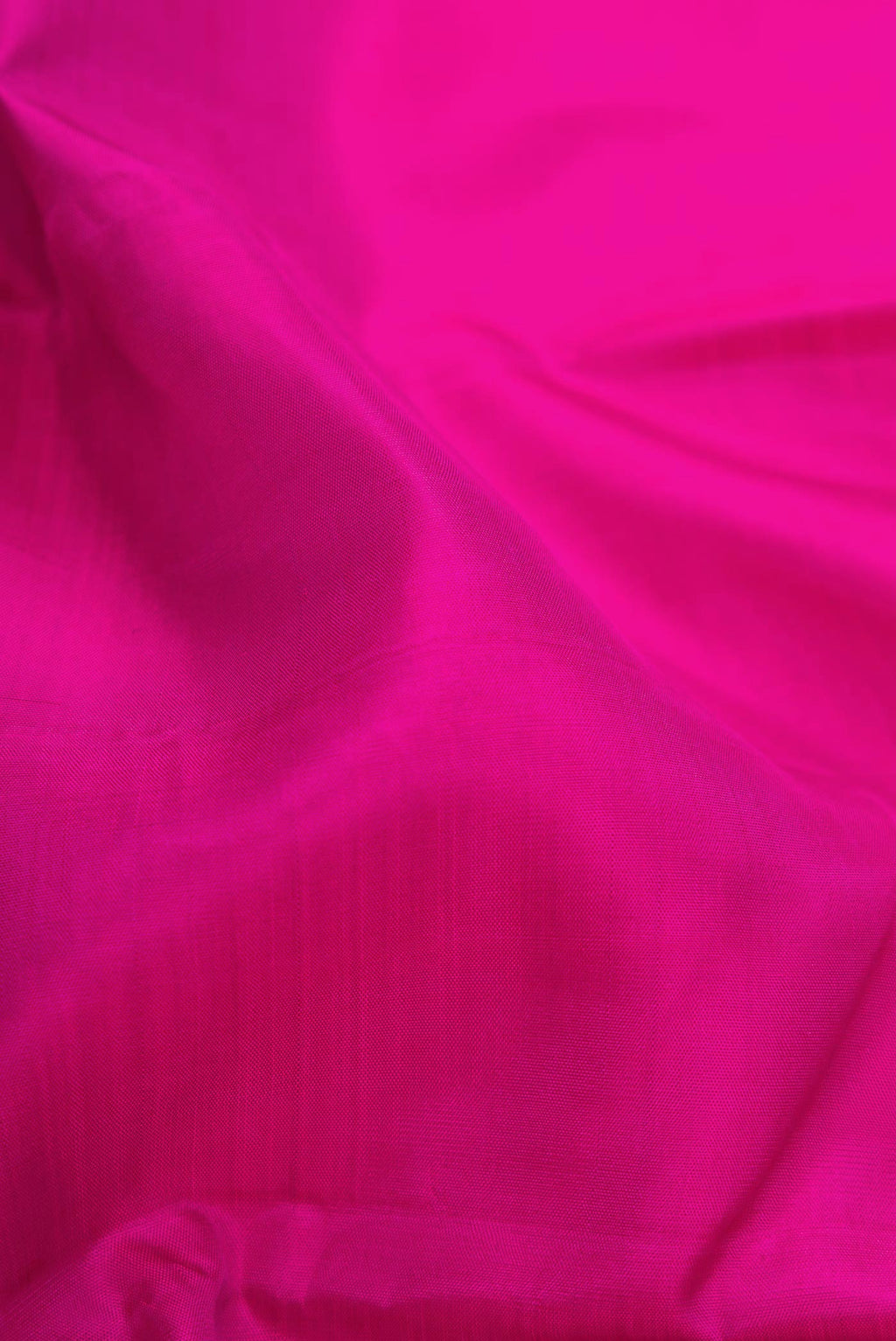 Close up of Magenta Dual Tone Kanjivaram Silk Saree with Plain Body and Zari Border.  displaying folds