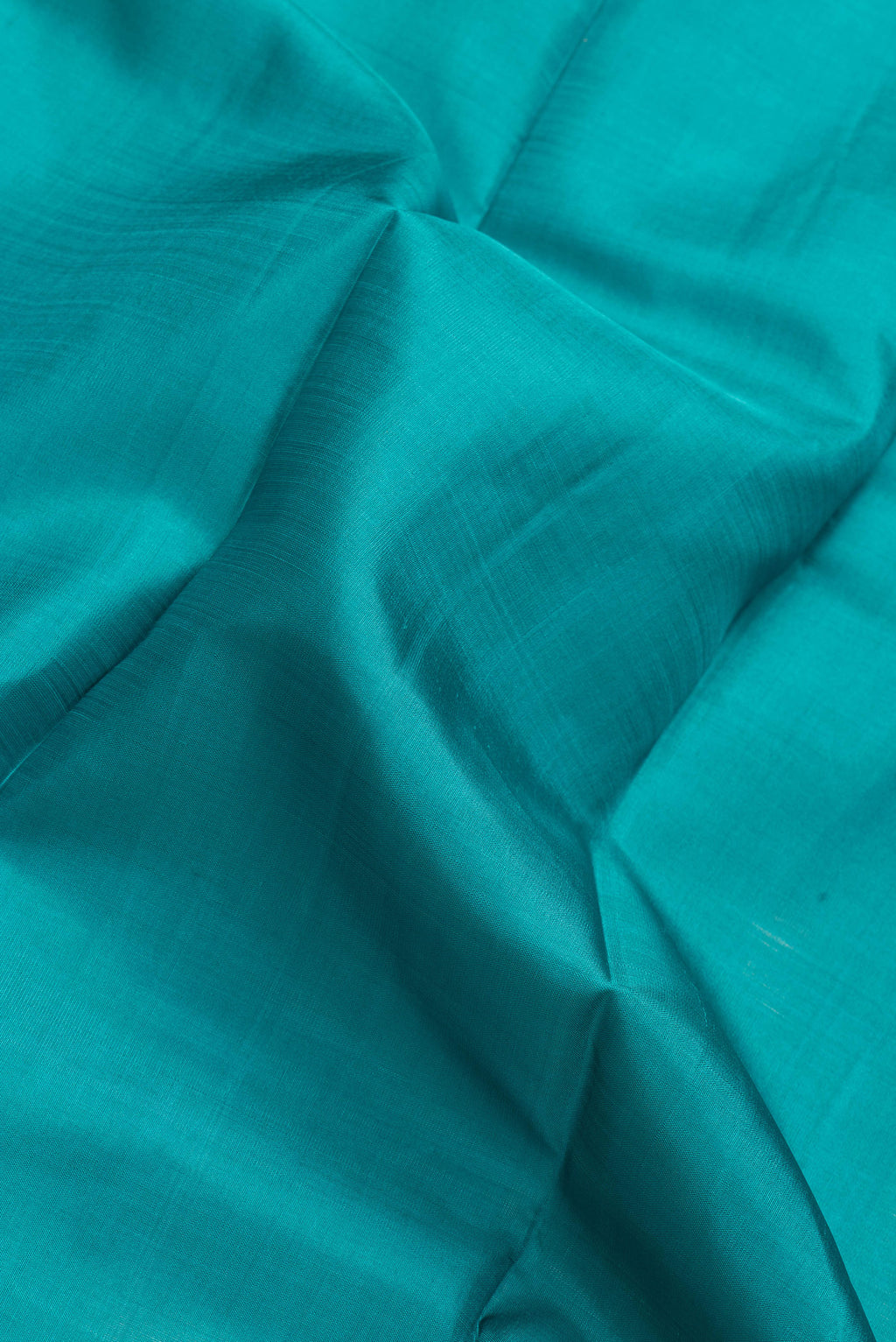 Close up of Green Dual Tone Kanjivaram Silk Saree with Plain Body and Zari Border.  displaying folds