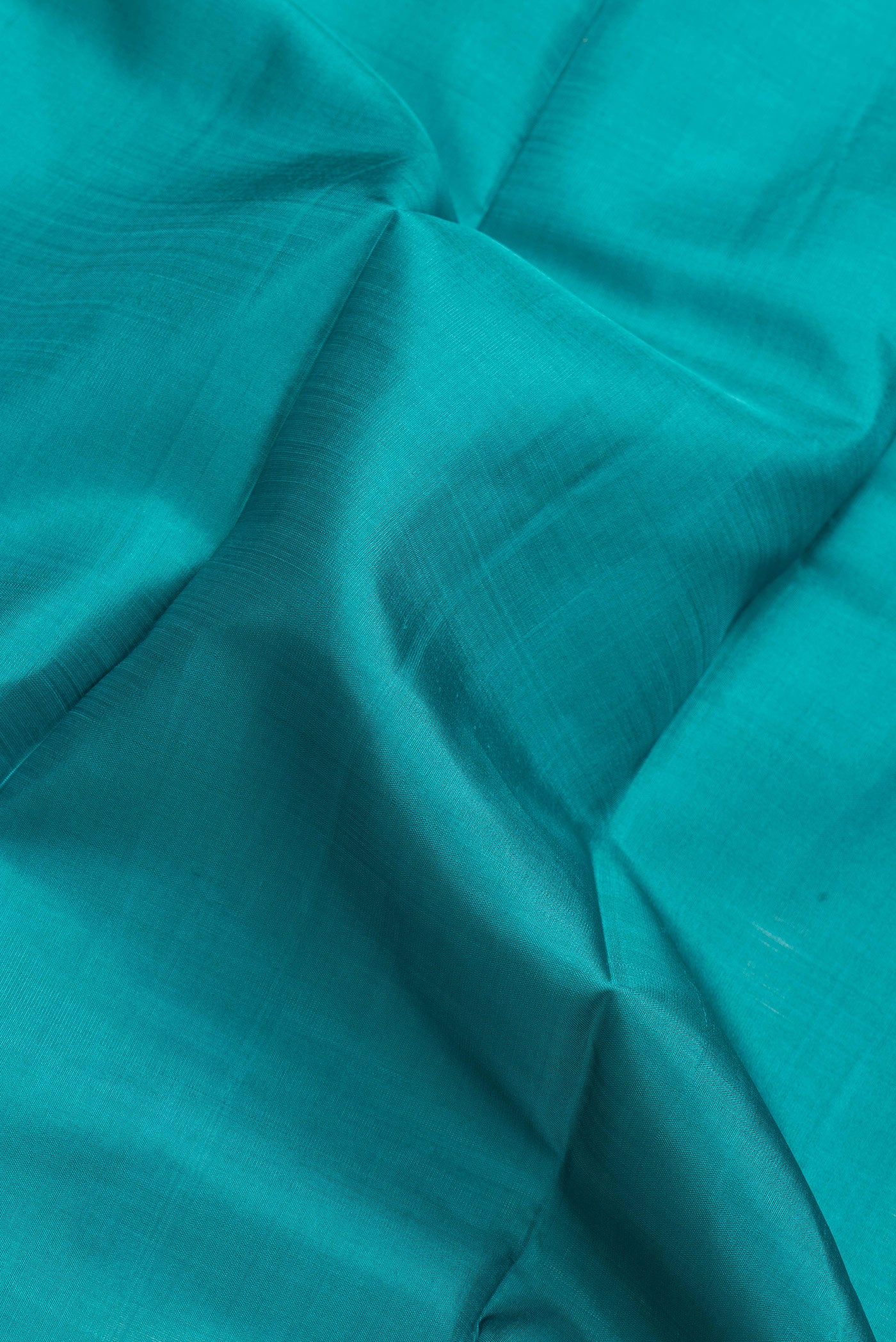 Close up of Green Dual Tone Kanjivaram Silk Saree with Plain Body and Zari Border.  displaying folds
