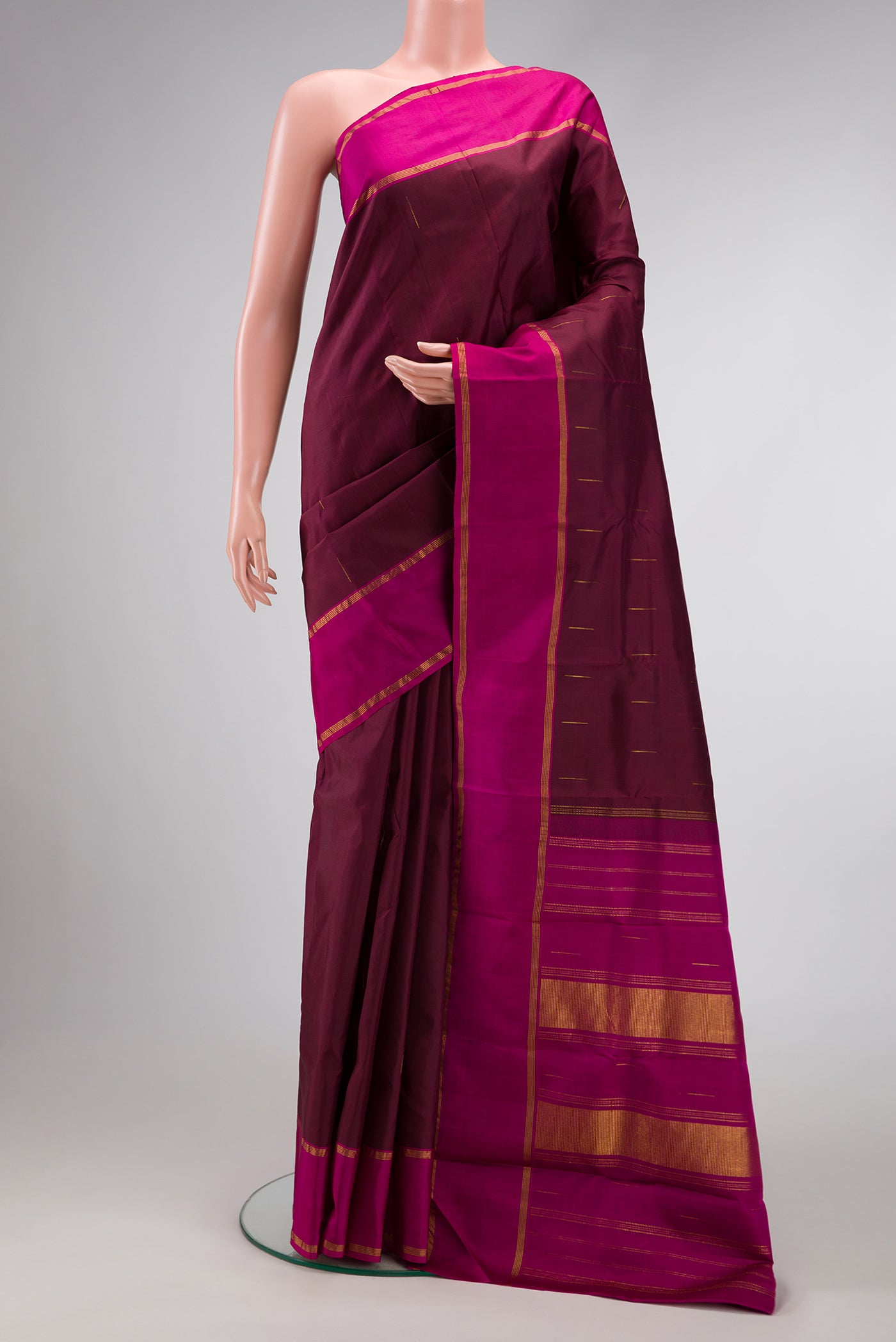 Burgundy Dual Tone Kanjivaram Silk Saree with Zari Butta on the body and Zari Border.  displayed on a mannequin