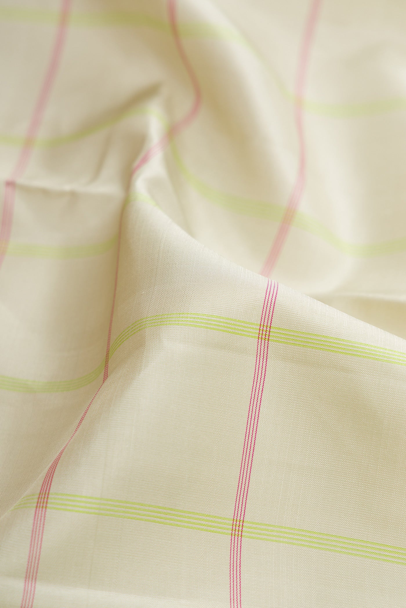 Close up of Beige Dual Tone Kanjivaram Silk Saree with Checked design on the body and Without Border.  displaying folds