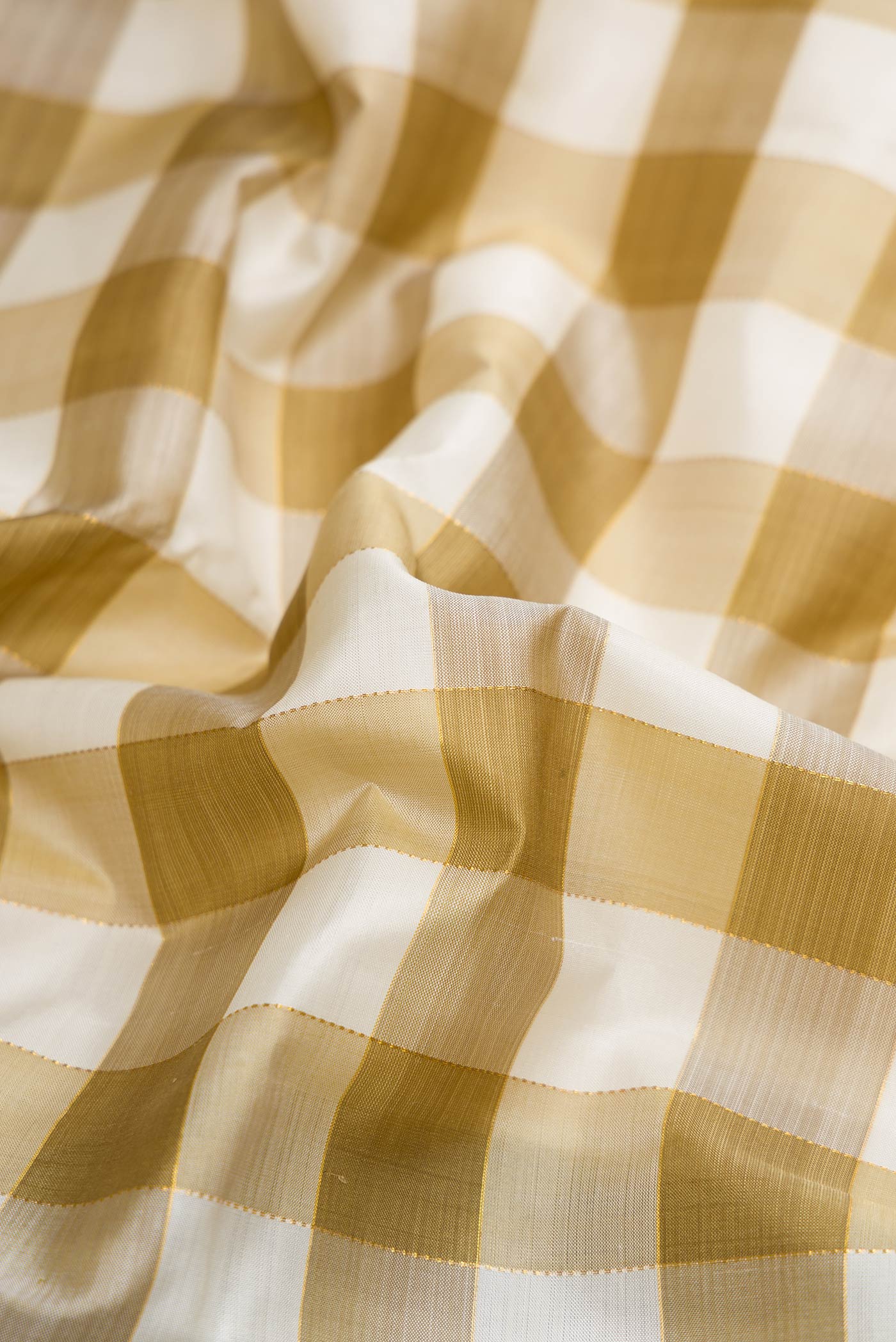 Close up of Pure Silk Pure Zari Green and Off White Color Kanchipuram Saree with Checked design on the body and Without Border displaying folds