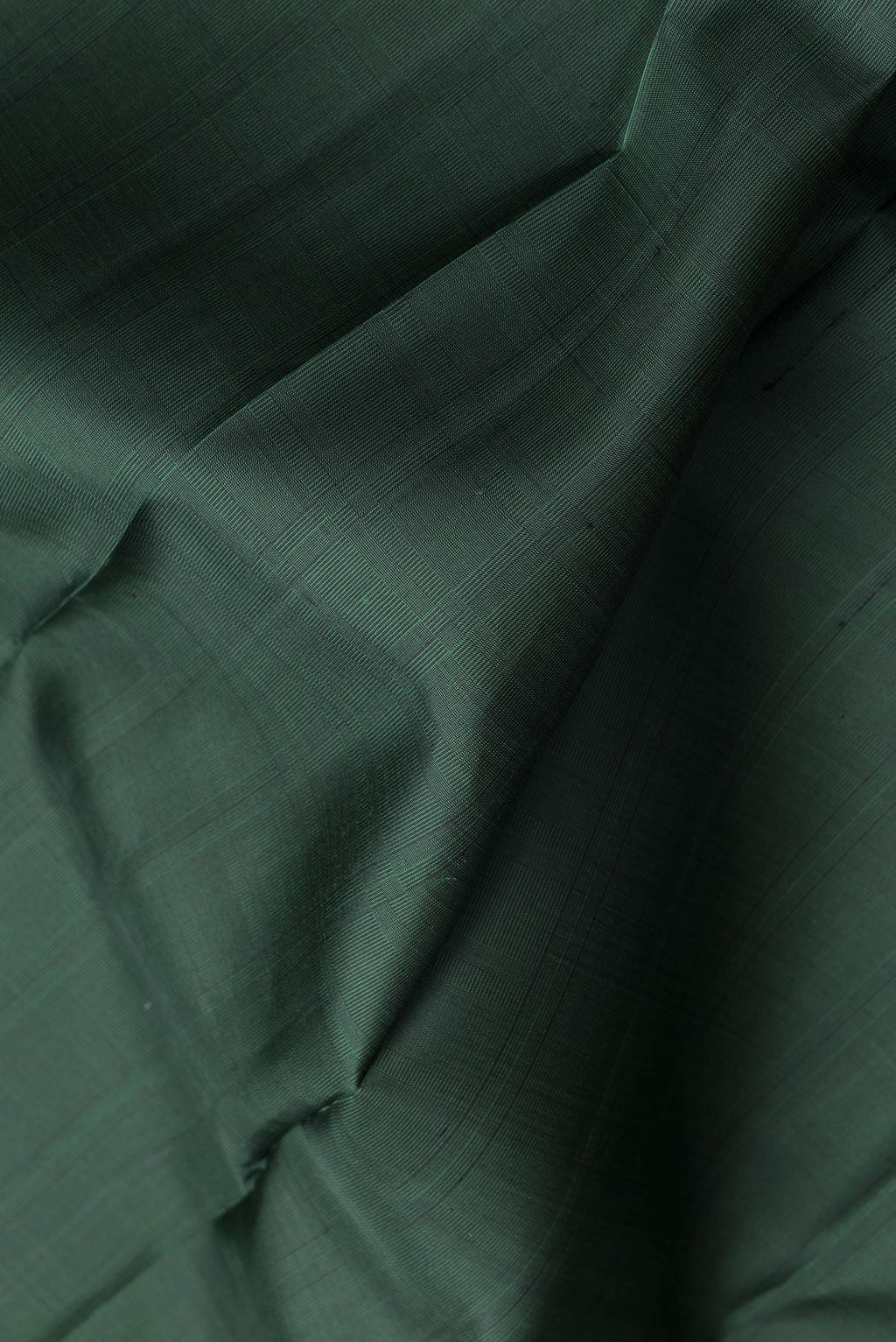 Close up of Bottle Green Dual Tone Kanjivaram Silk Saree with Checked design on the body and Without Border.  displaying folds
