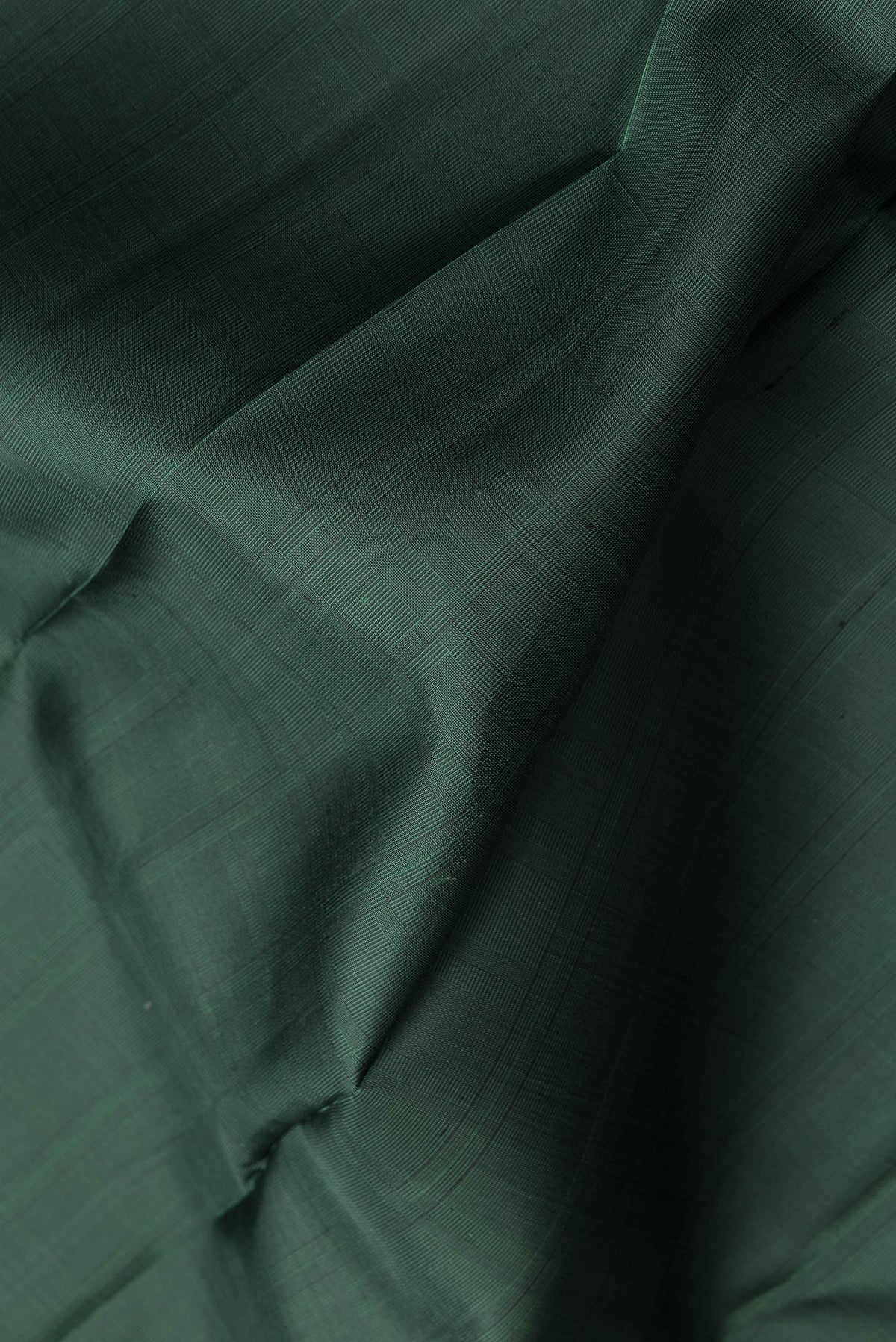 Close up of Bottle Green Dual Tone Kanjivaram Silk Saree with Checked design on the body and Without Border.  displaying folds