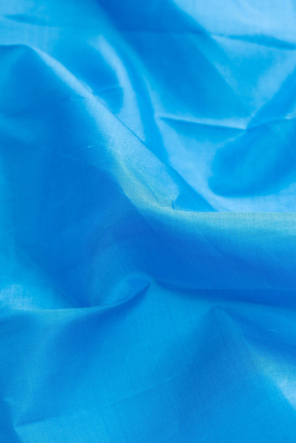 Close up of Sky Blue Dual Tone Kanchipuram Silk Saree with Plain Body and Fancy Border.  displaying folds