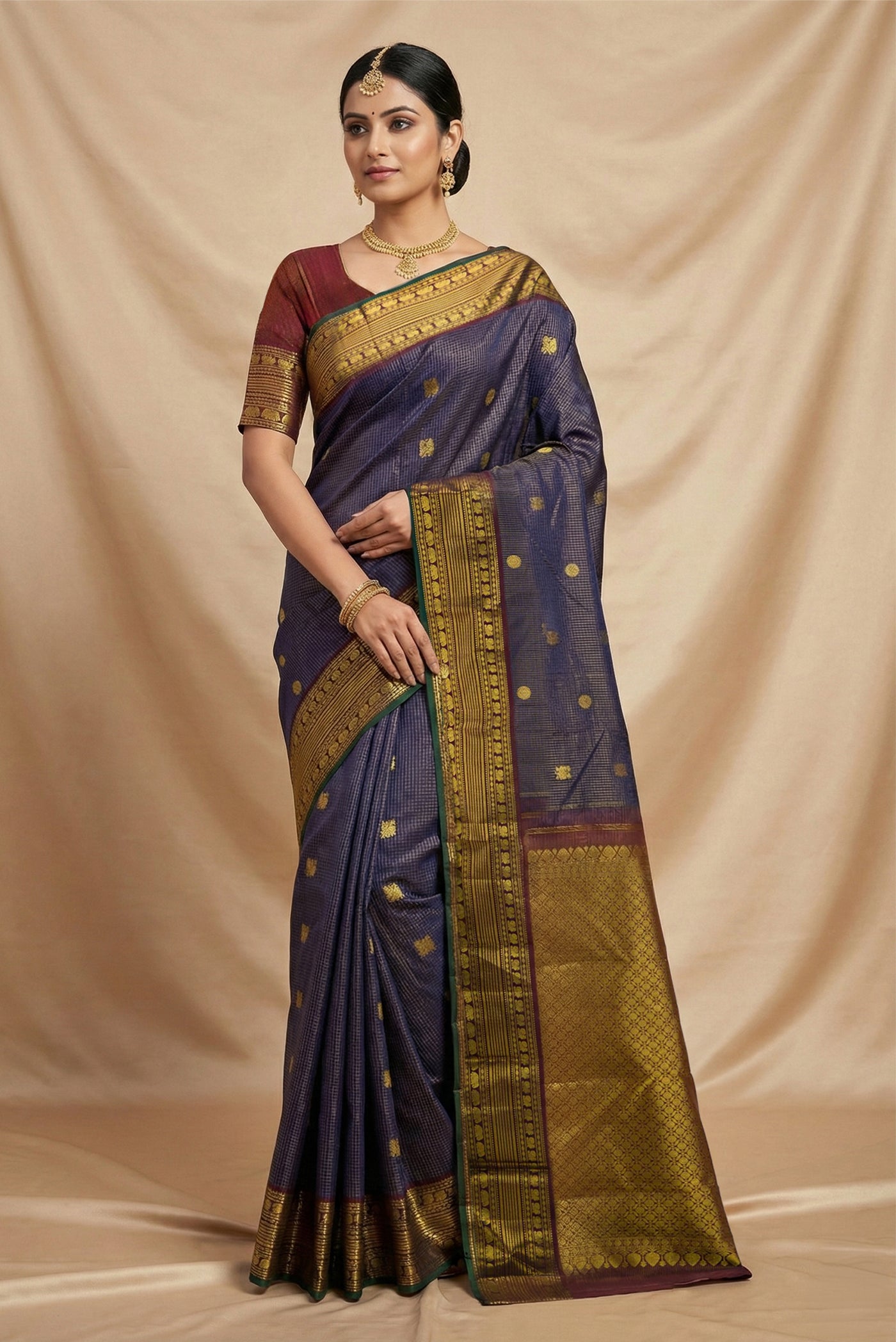 Model wearing a Navy Blue Kanchipuram Silk Saree with Zari Butta on the body and Zari Border.