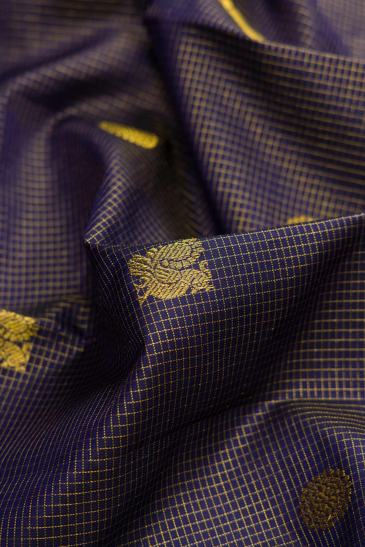 Close up of Violet Dual Tone Kanjivaram Silk Saree with Zari Butta on the body and Zari Border.  displaying folds